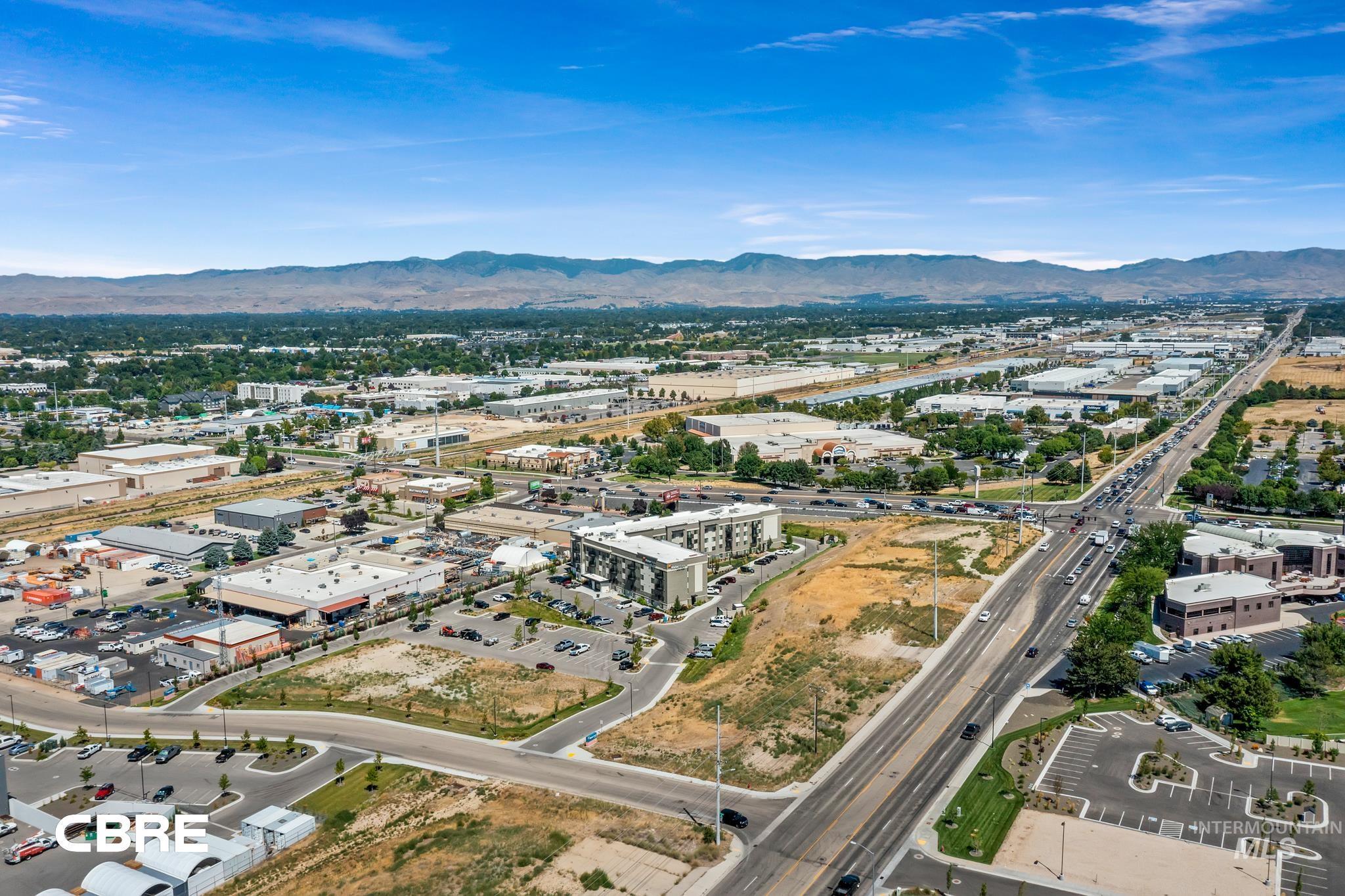Aerial view of property and surrounding area featuring a mountain backdrop