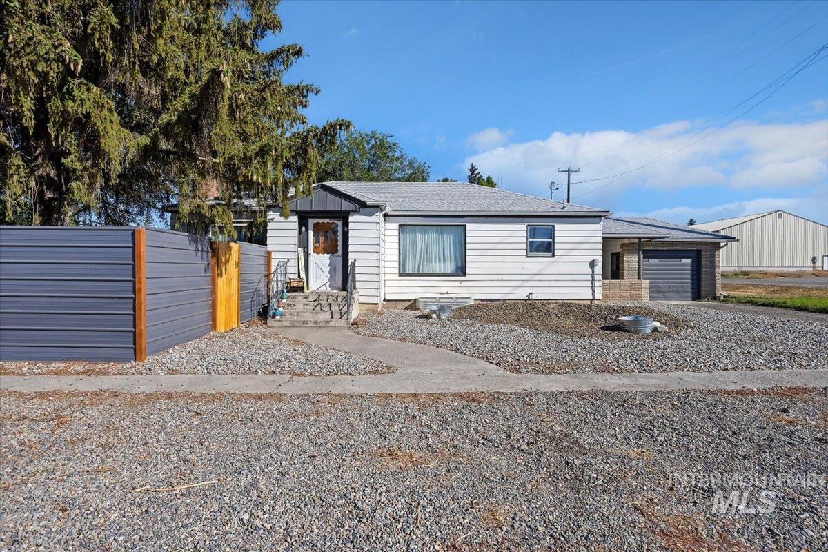 View of front of home featuring an attached garage, roof with shingles, and driveway