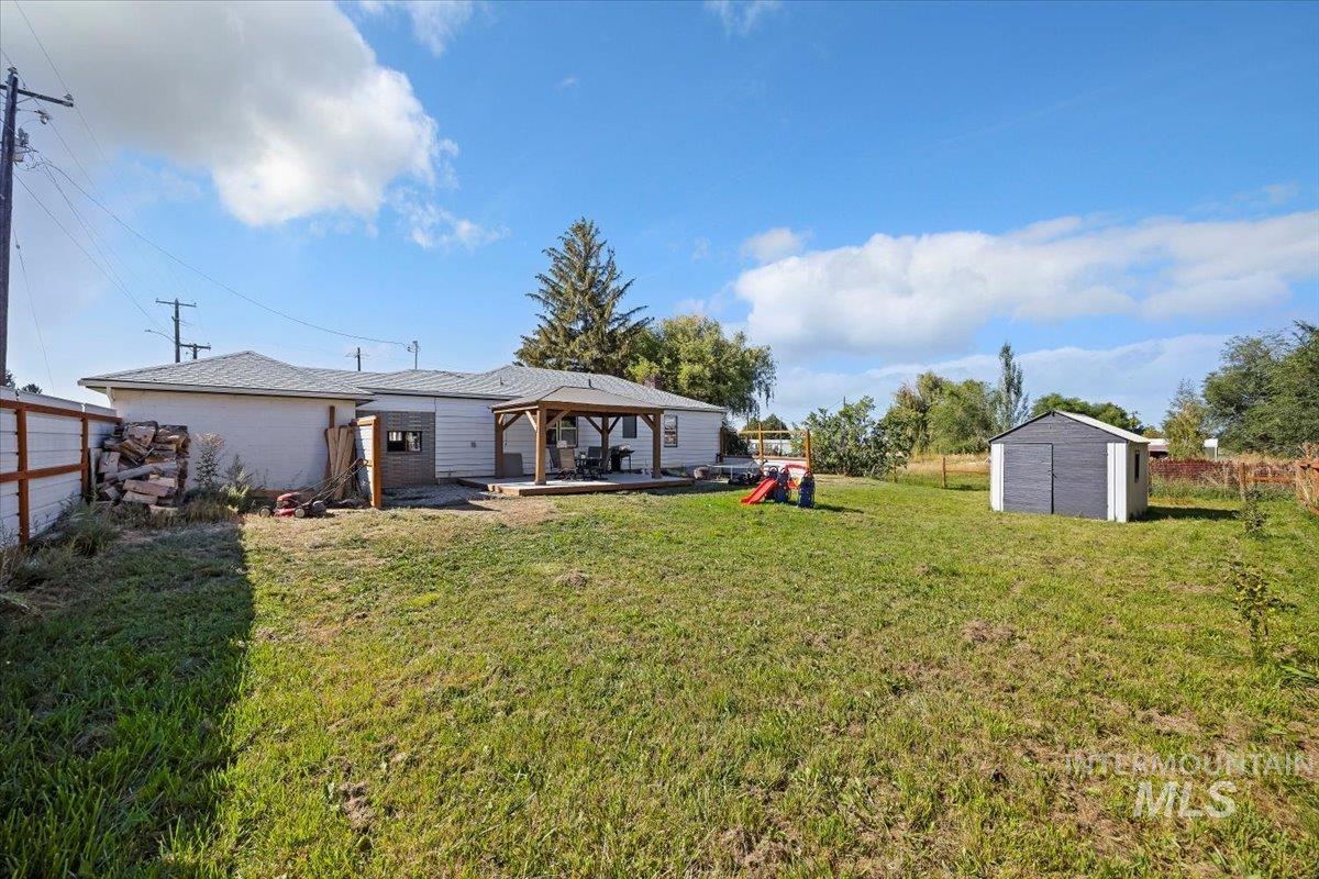 View of yard with a storage shed, a gazebo, and a patio