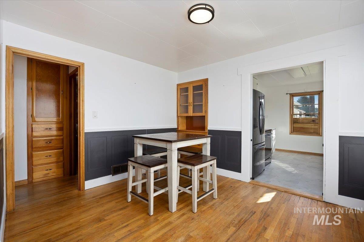 Dining room featuring light wood-style flooring and wainscoting