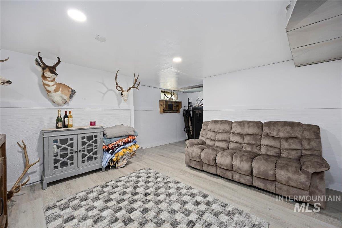 Living area with wood finished floors, a wall mounted air conditioner, and recessed lighting