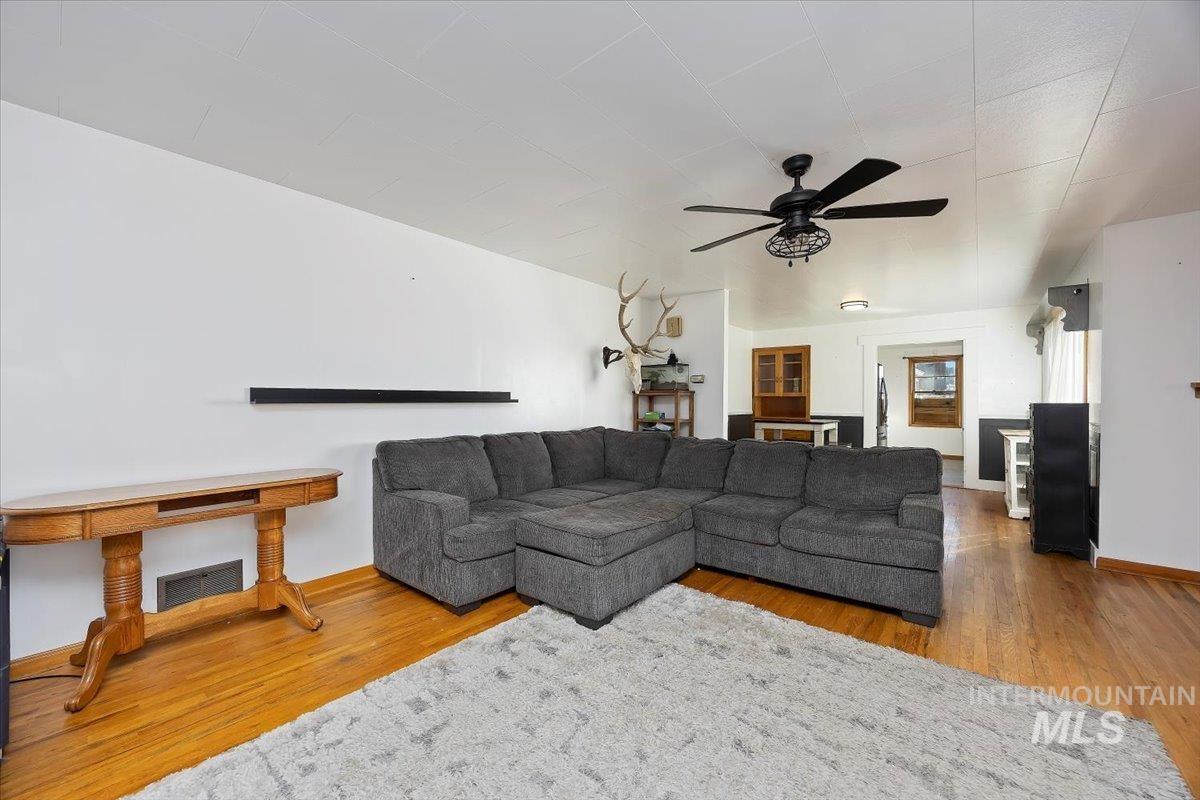 Living area with a ceiling fan and wood finished floors