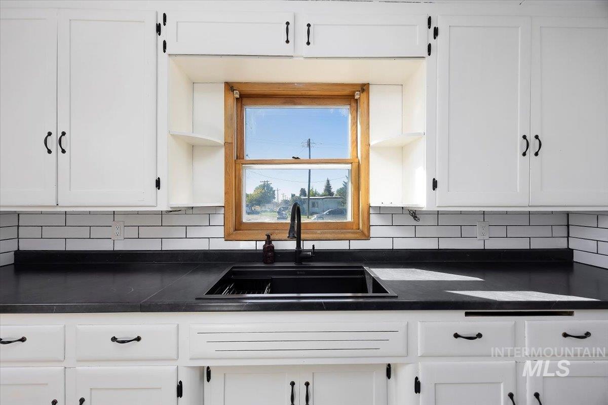Kitchen with white cabinetry and backsplash