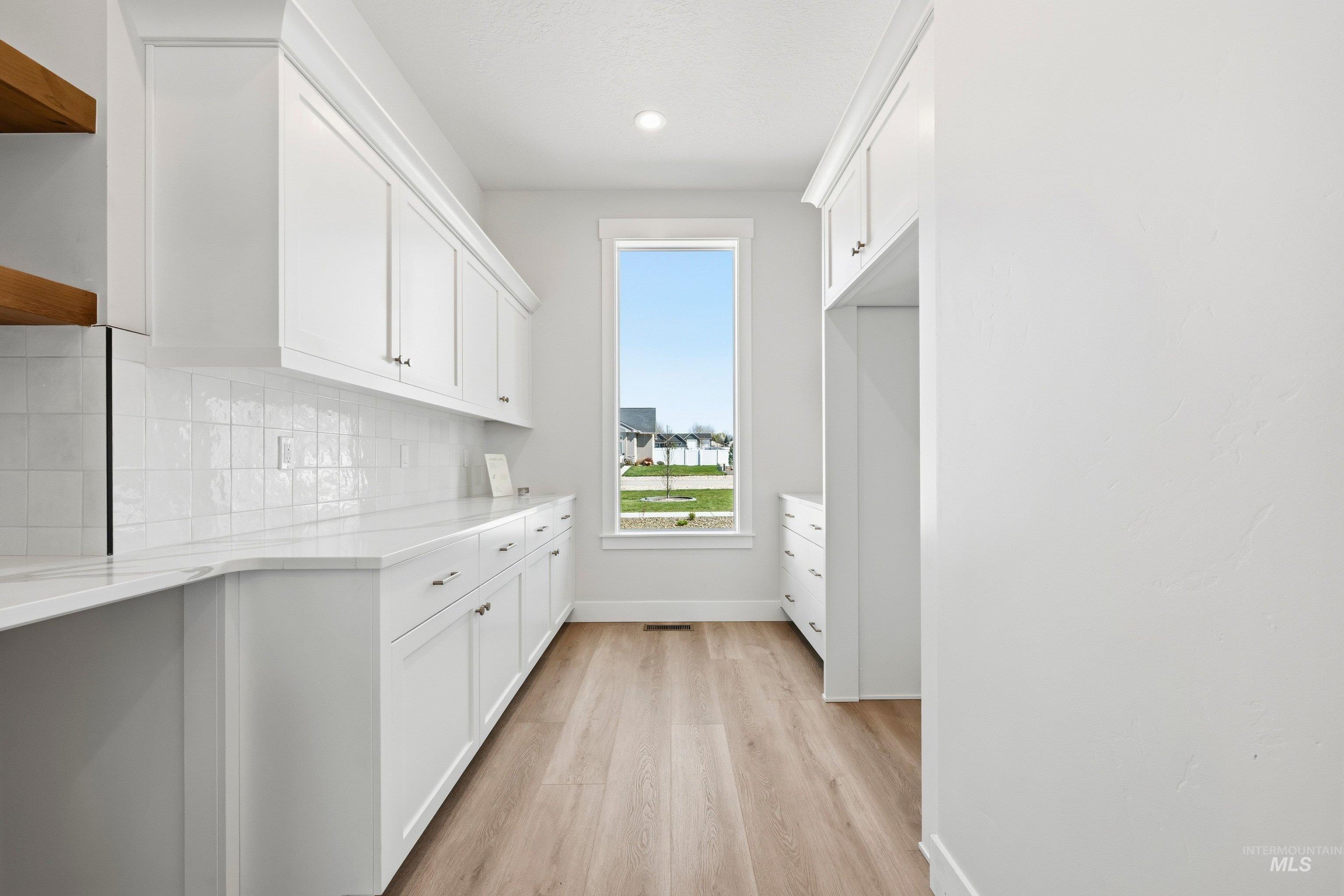 Laundry room with baseboards and light wood-style floors