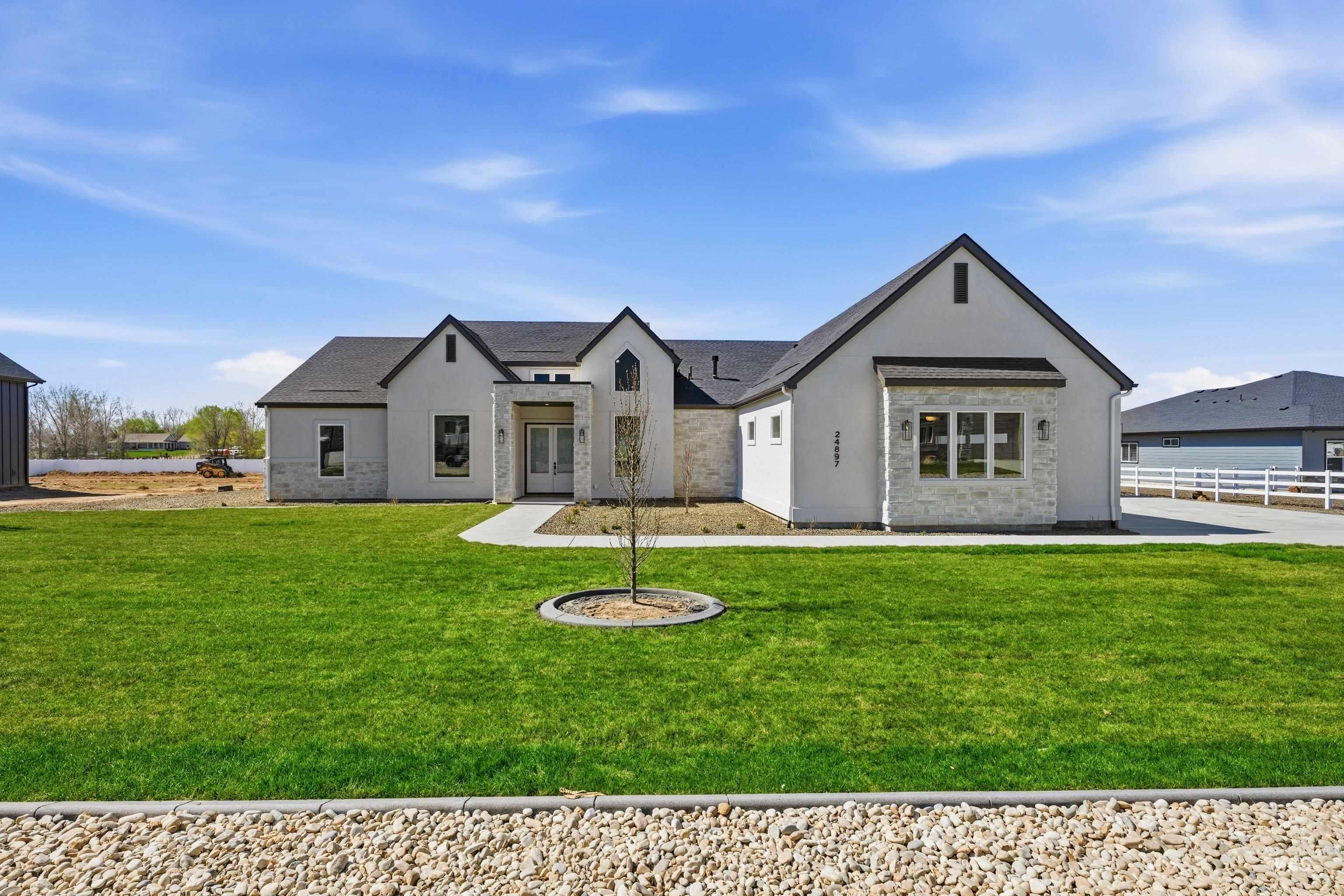 View of front facade featuring stucco siding and stone siding