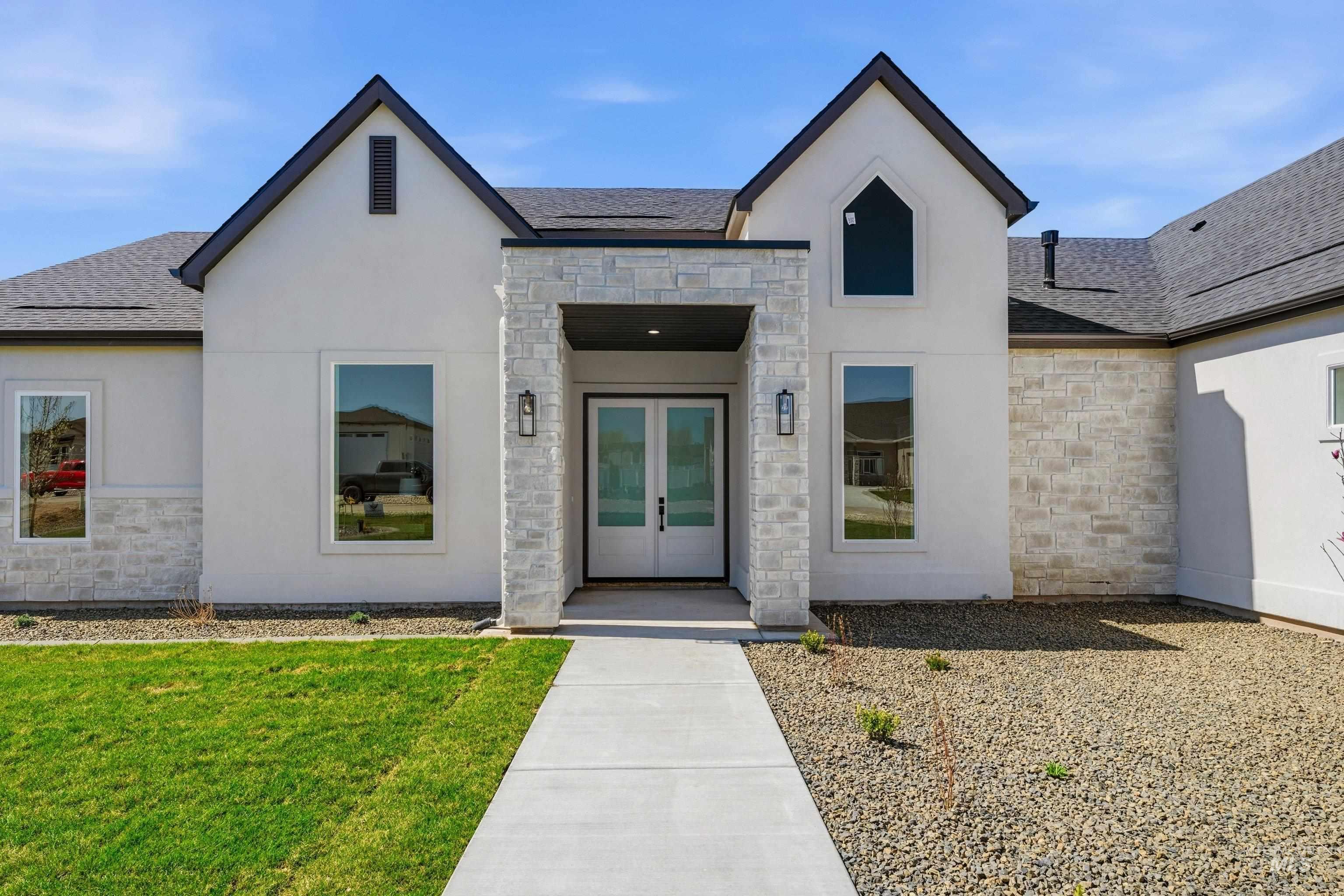 Entrance to property with stone siding, french doors, and stucco siding