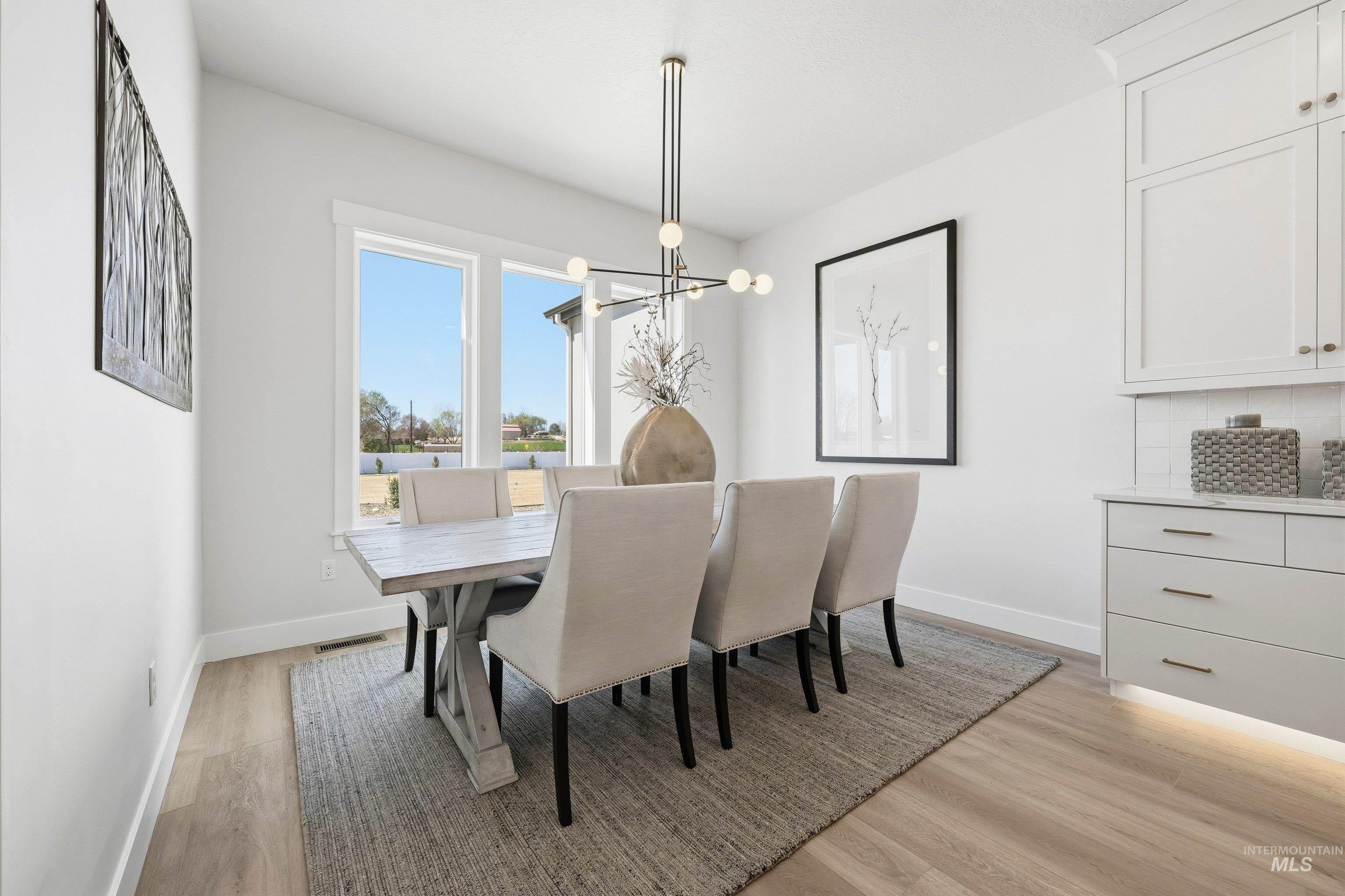 Dining room with light wood-style flooring and hanging lights