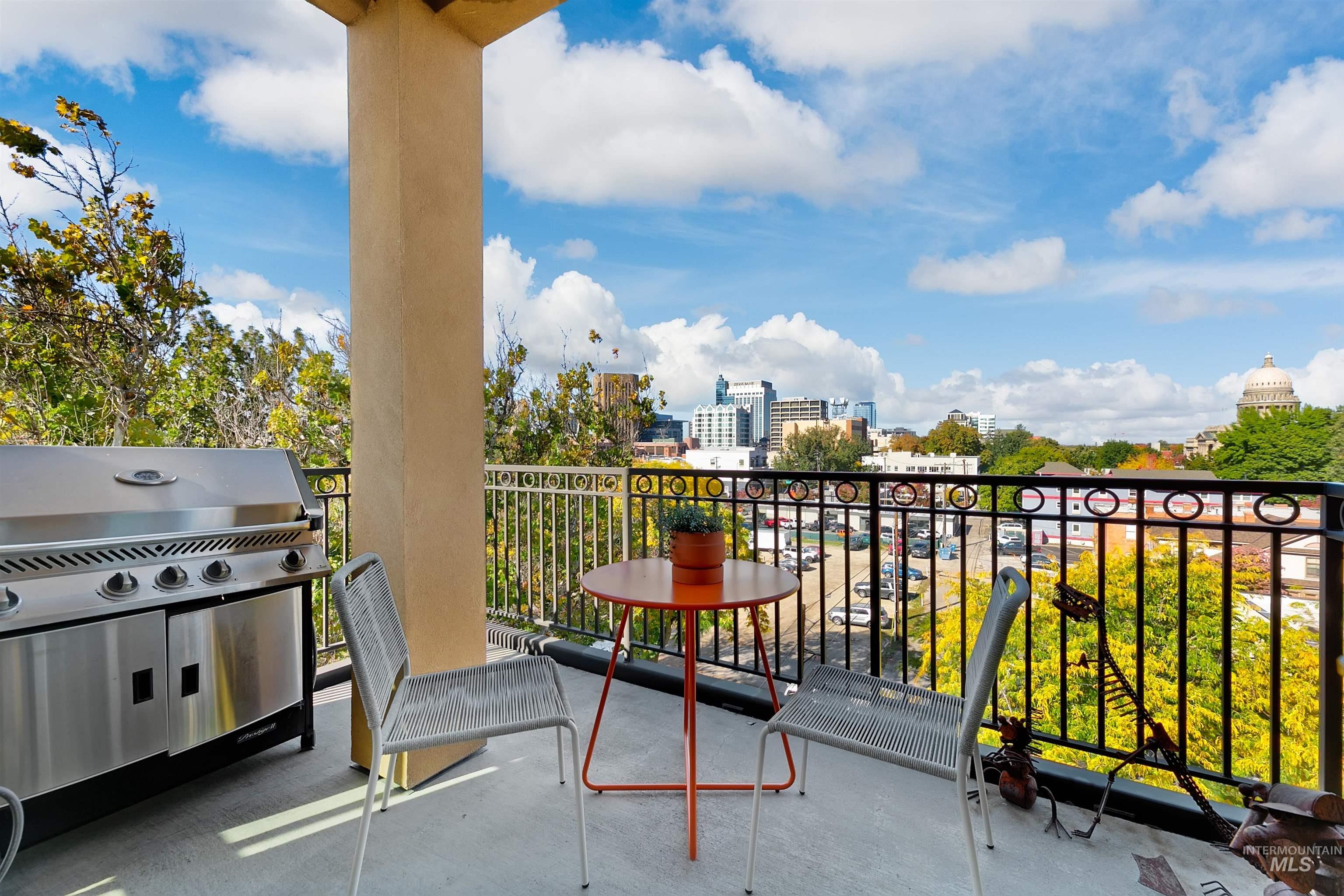 Balcony featuring area for grilling and a city view