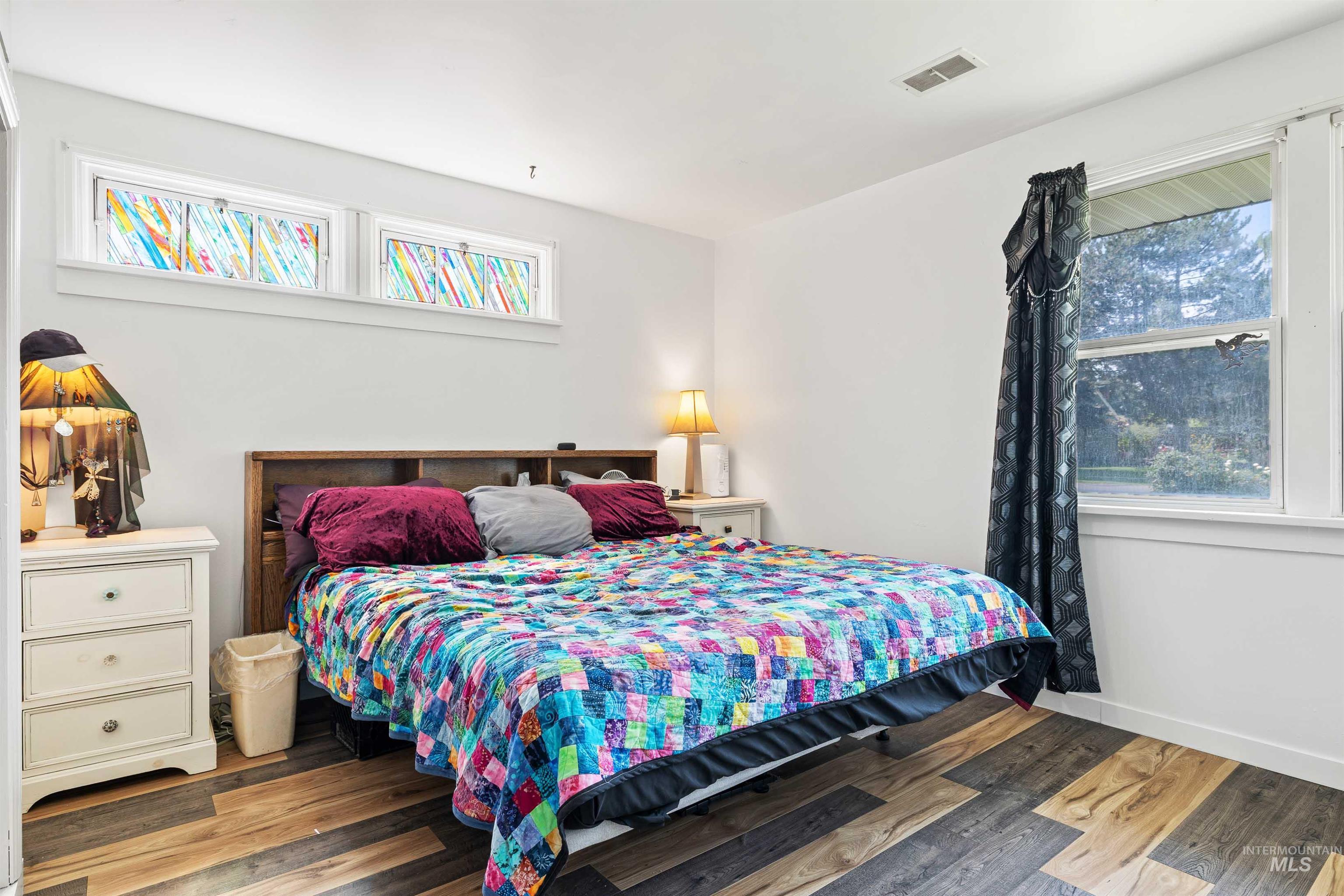 Bedroom with multiple windows and wood finished floors