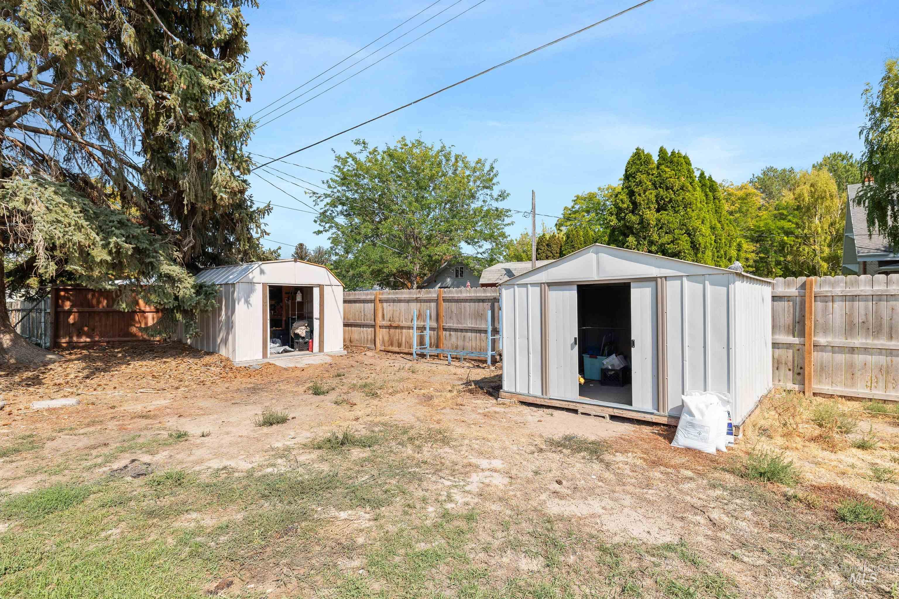 Fenced backyard featuring a storage shed