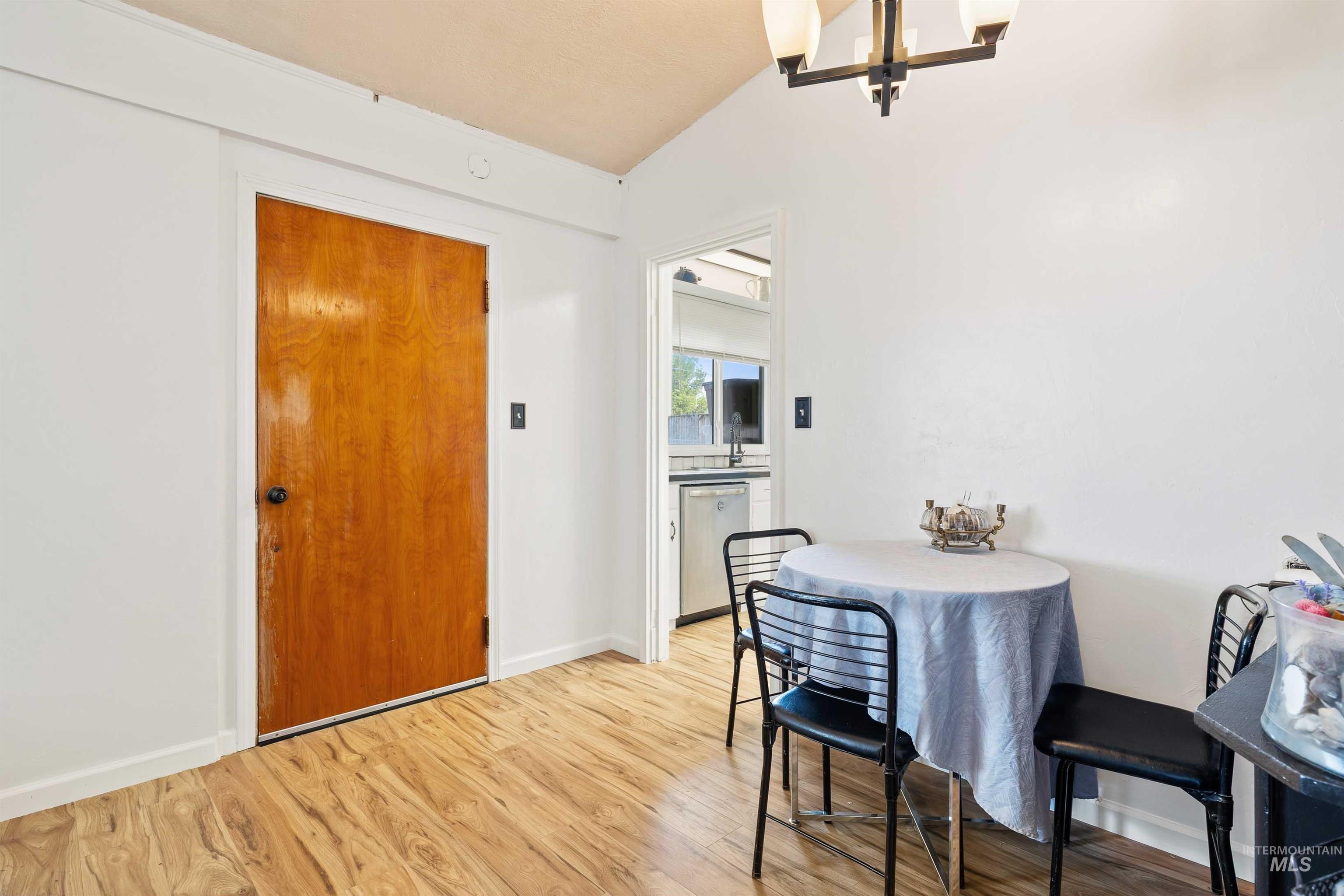 Dining area with light wood-type flooring and a chandelier