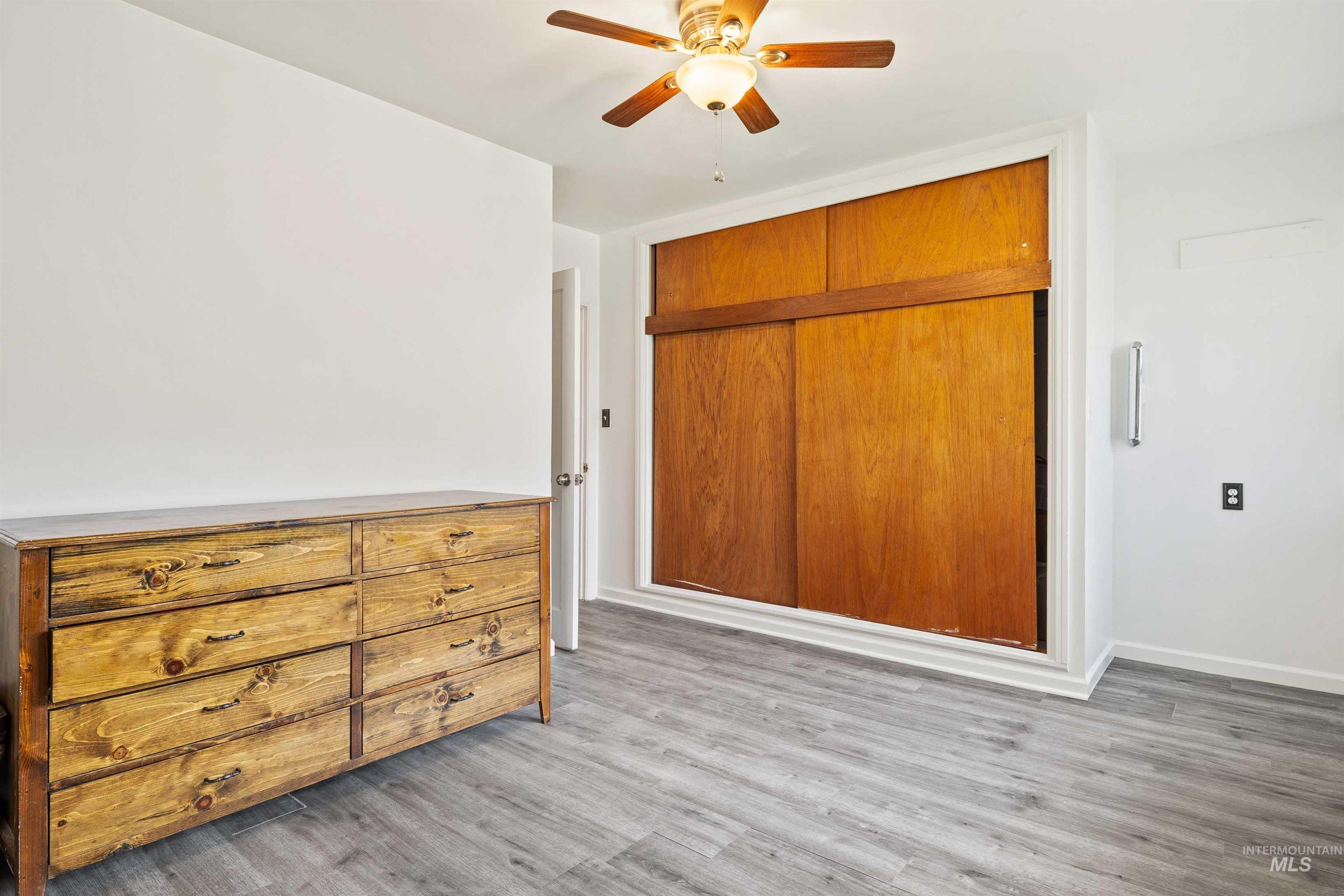 Unfurnished bedroom with light wood finished floors, ceiling fan, and a closet