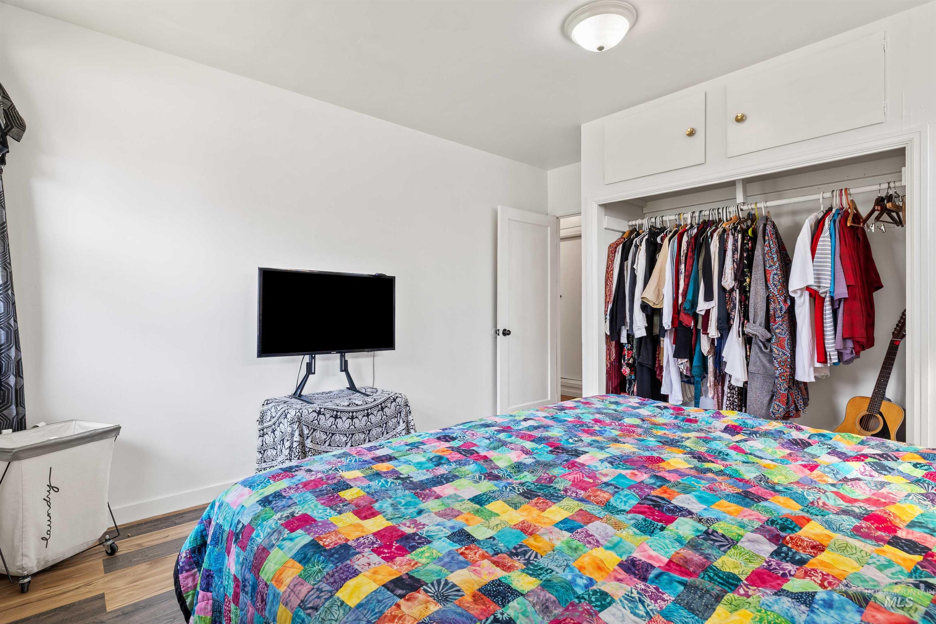 Bedroom with wood finished floors and a closet