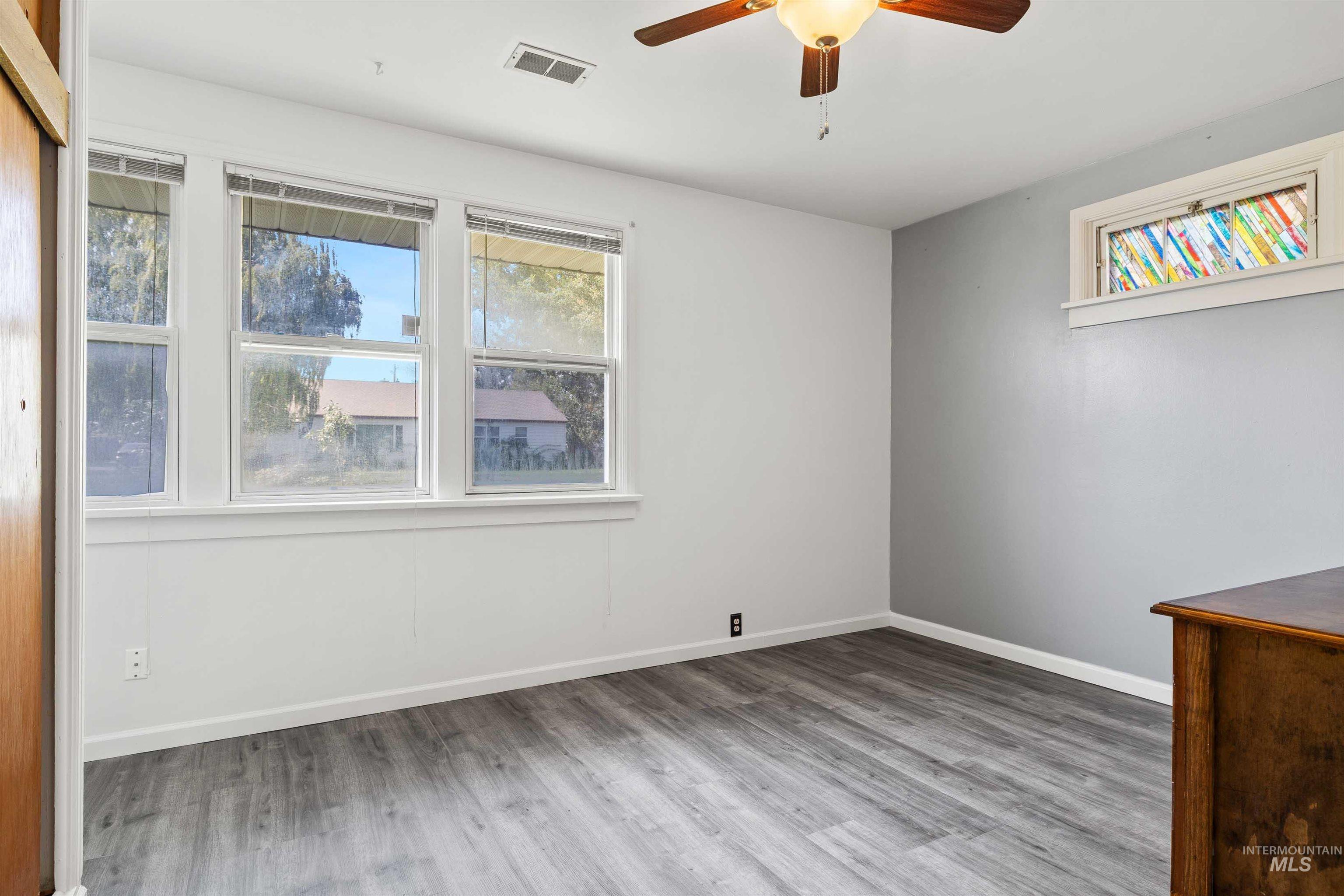 Empty room featuring light wood-style floors and ceiling fan