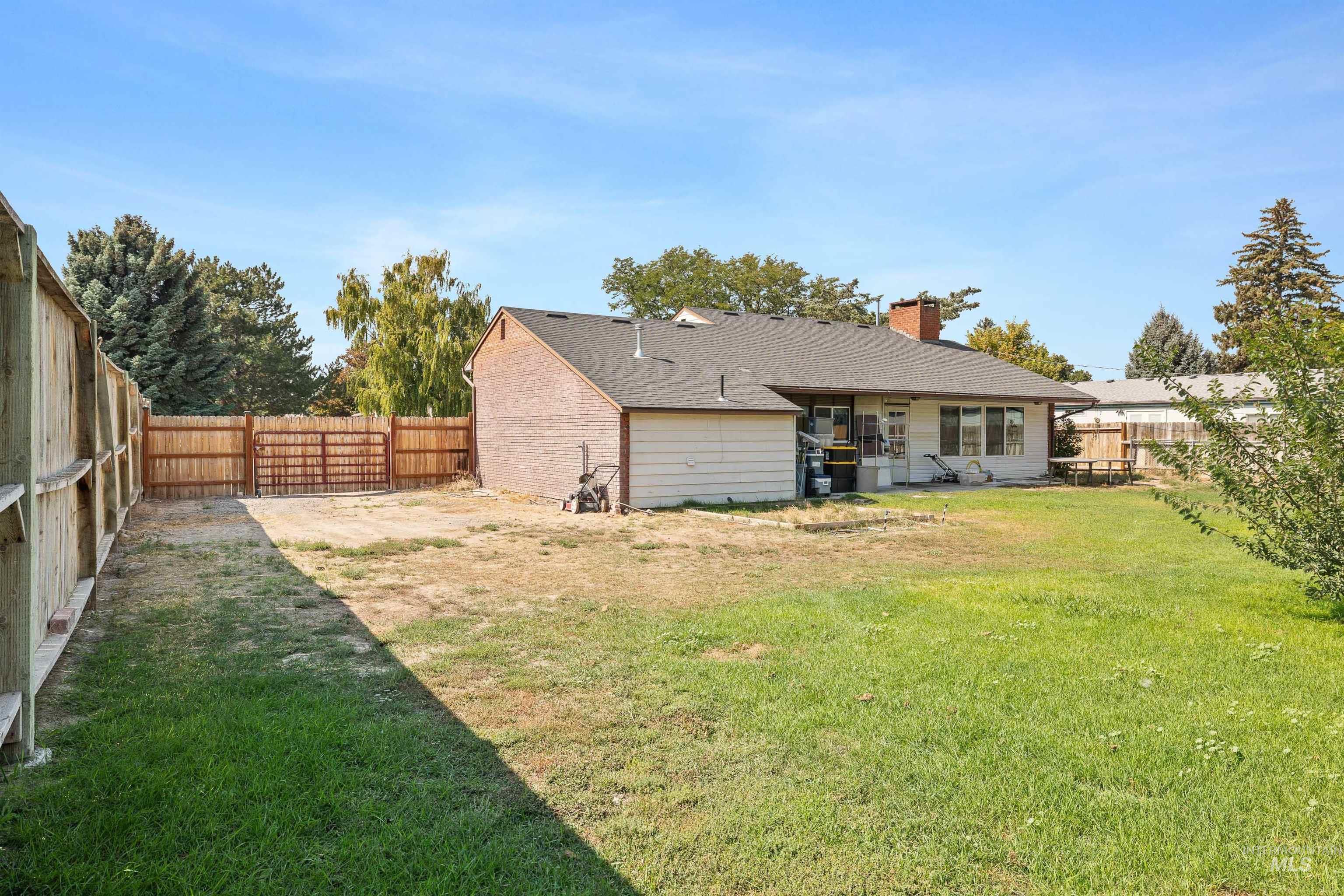 Rear view of property with a fenced backyard, a chimney, a shingled roof, and a patio area