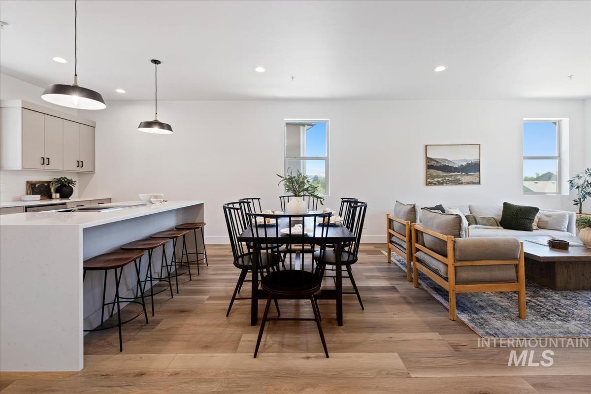 Dining area with recessed lighting and light wood-style flooring
