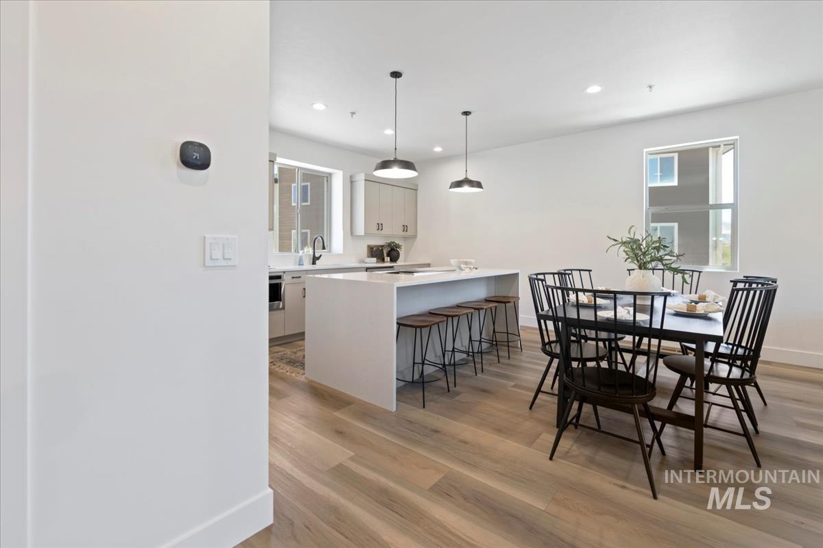 Dining space featuring light wood-style floors, healthy amount of natural light, and recessed lighting