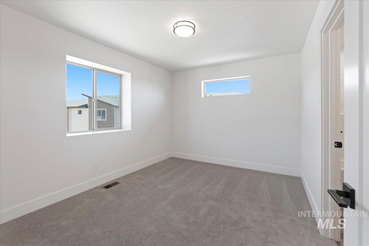 Empty room featuring light carpet and baseboards