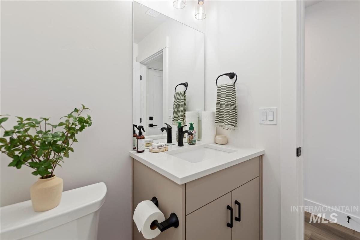 Half bath featuring vanity and wood finished floors