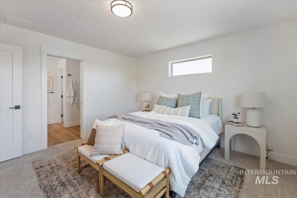 Bedroom with light colored carpet and ensuite bath