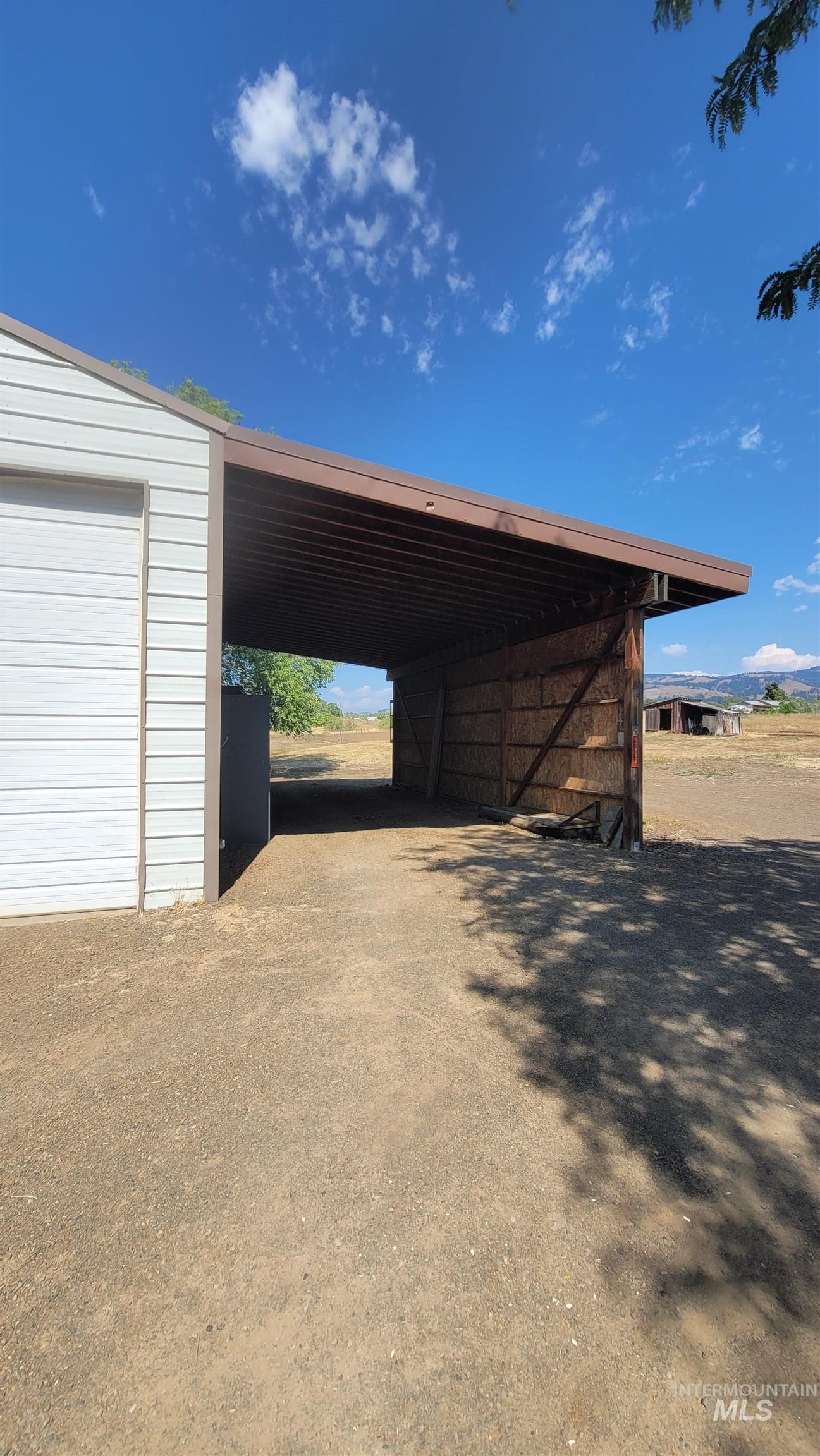 Garage featuring an attached carport