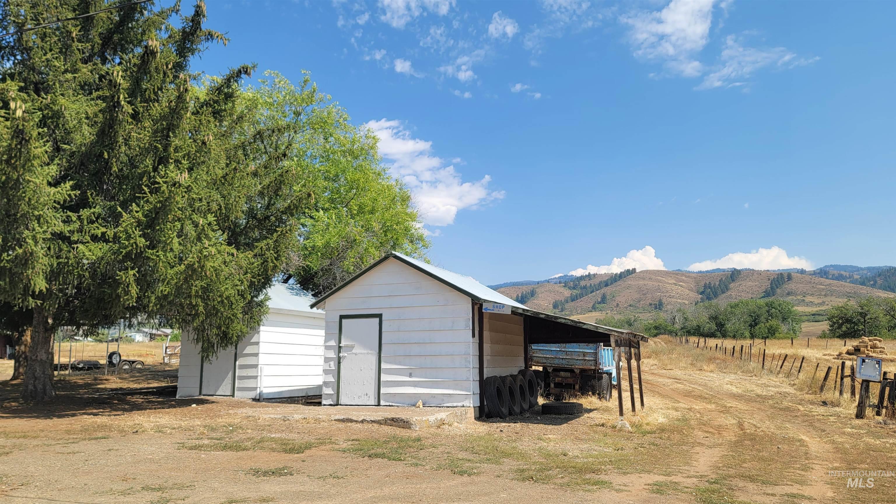 View of shed featuring a carport, a mountain view, and a rural view