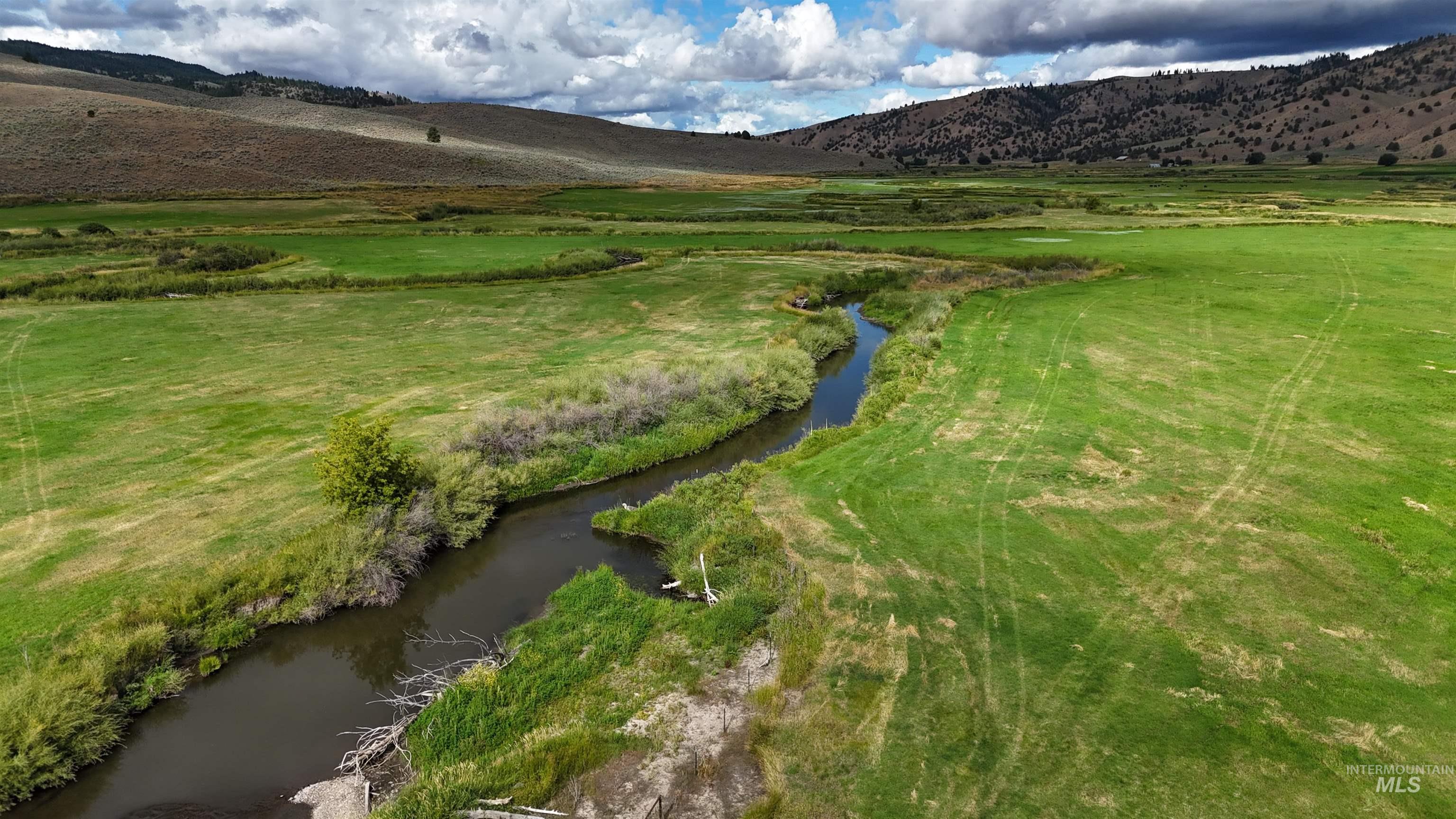 View of mountain backdrop with rural landscape and a large body of water