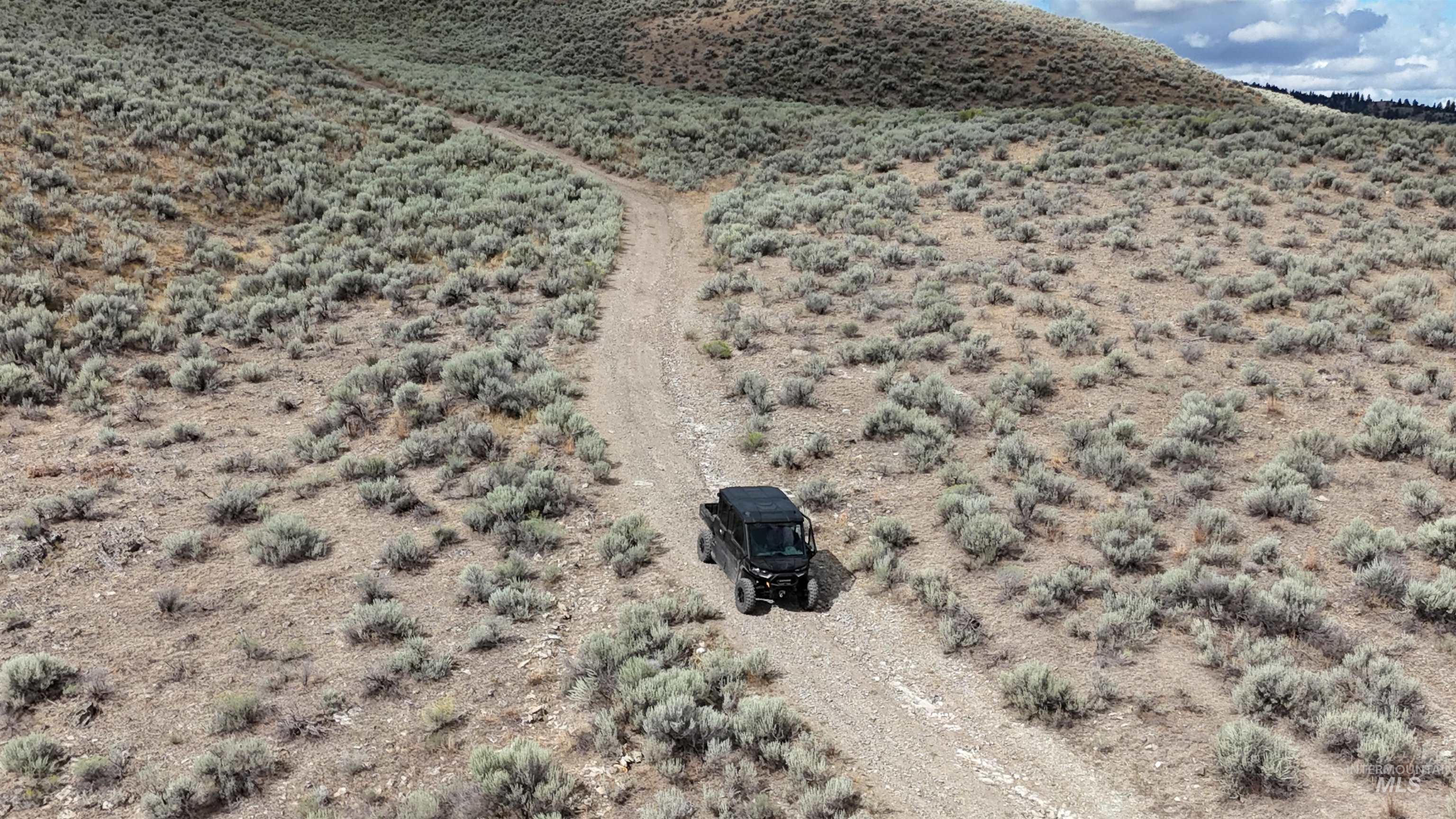 Overview of rural landscape featuring a desert landscape and a mountain backdrop