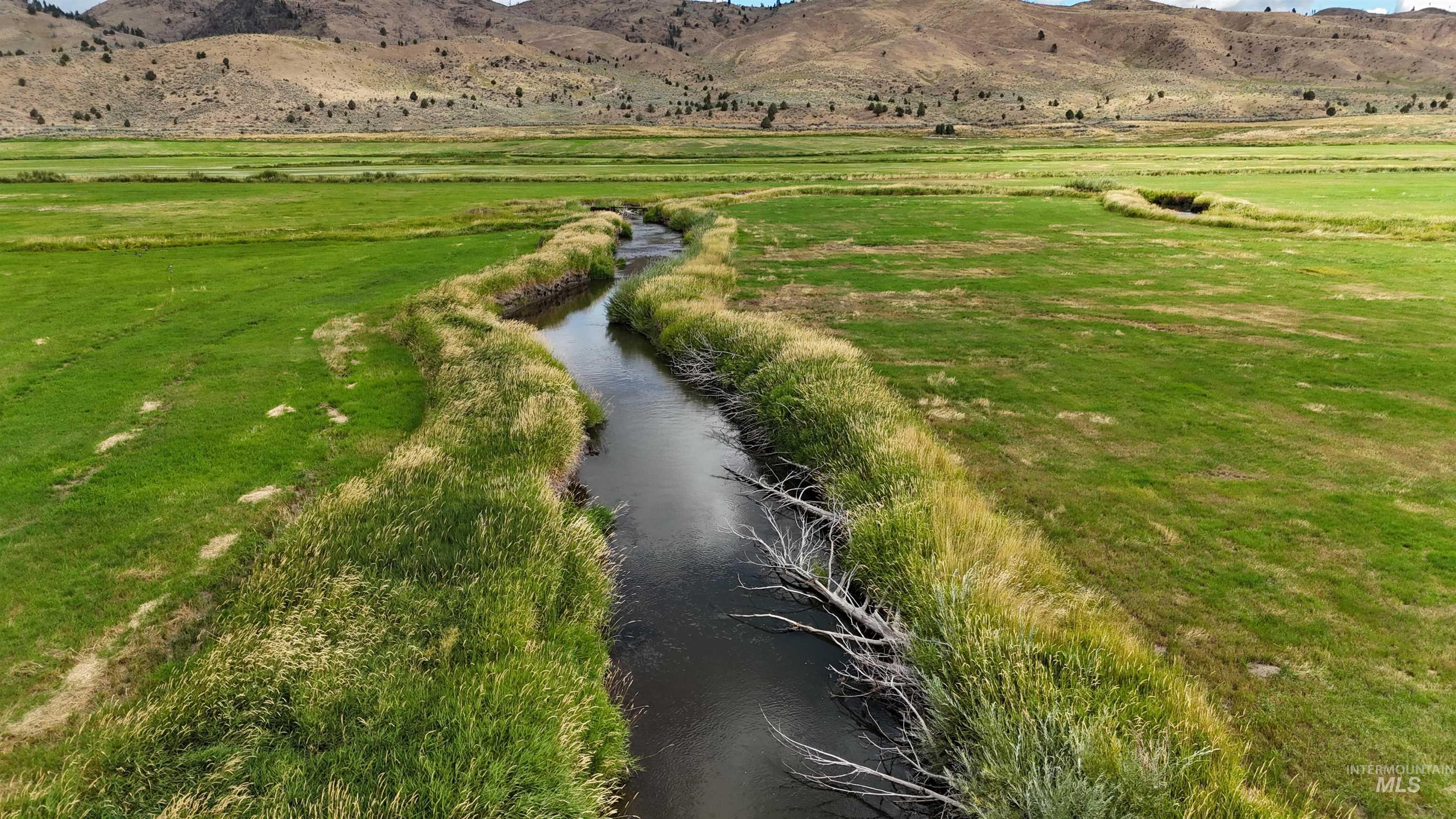 View of mountain backdrop with rural landscape and a large body of water
