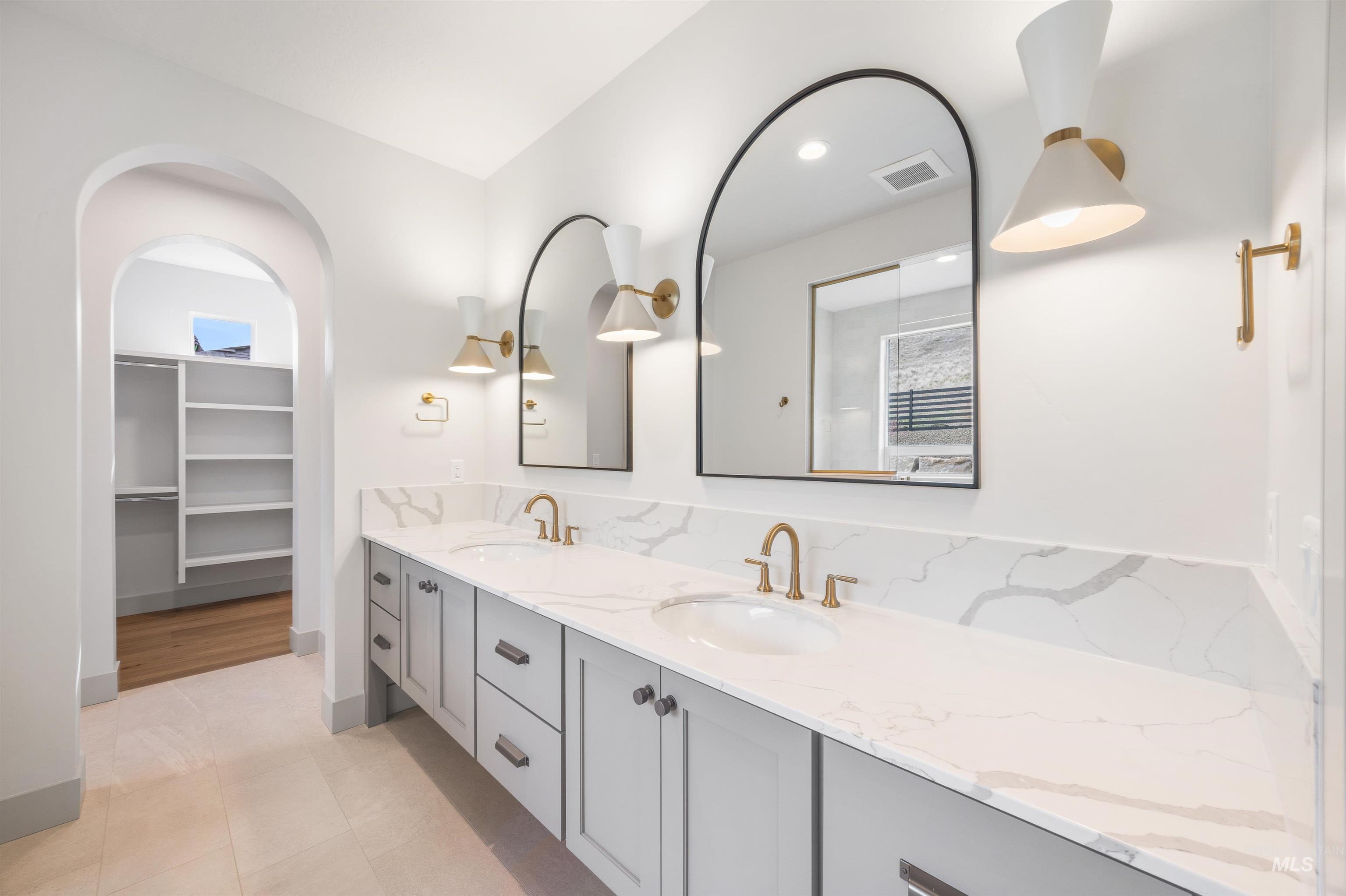 Full bathroom featuring double vanity, a spacious closet, light tile patterned flooring, and recessed lighting