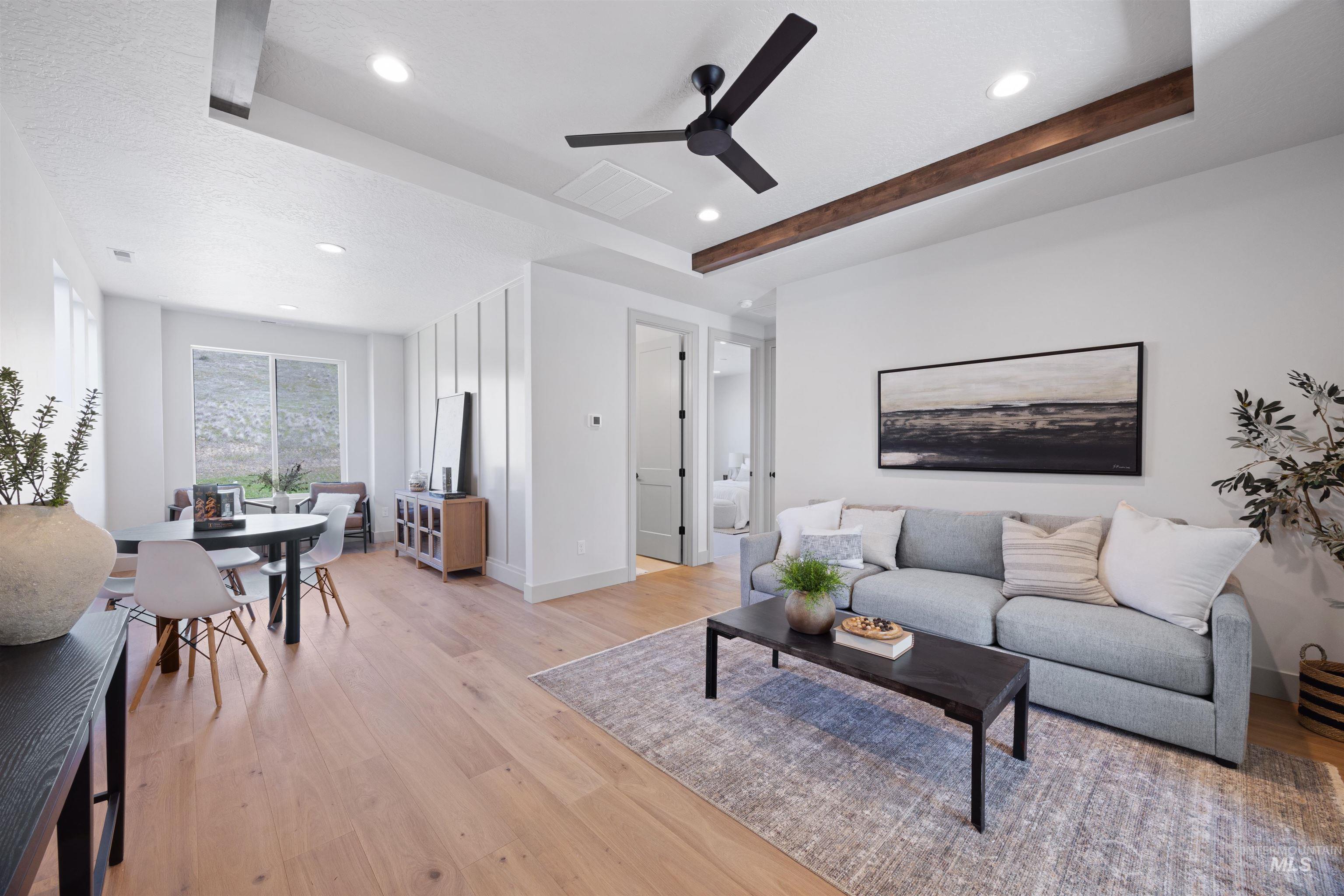 Living room with light wood-type flooring, ceiling fan, recessed lighting, and beam ceiling