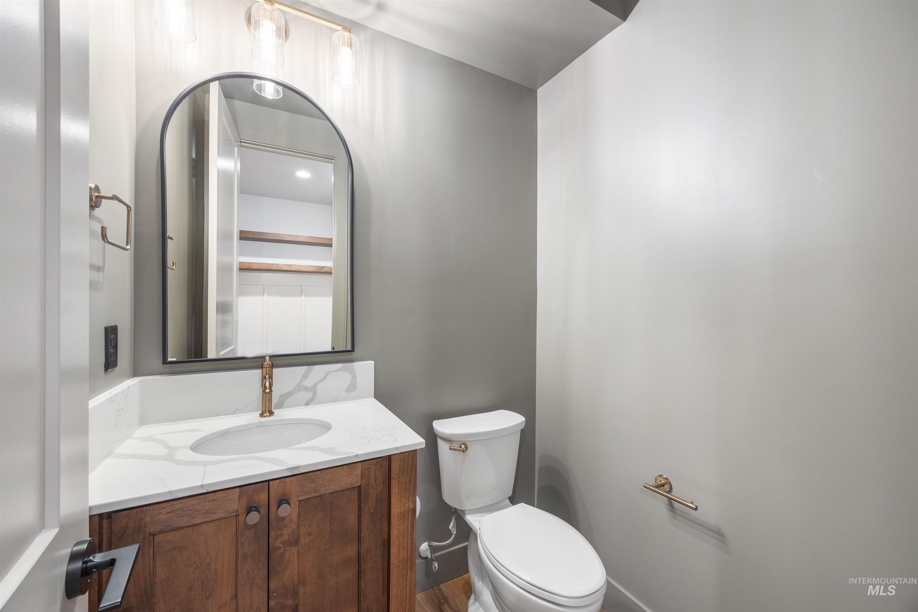 Half bathroom with vanity and toilet