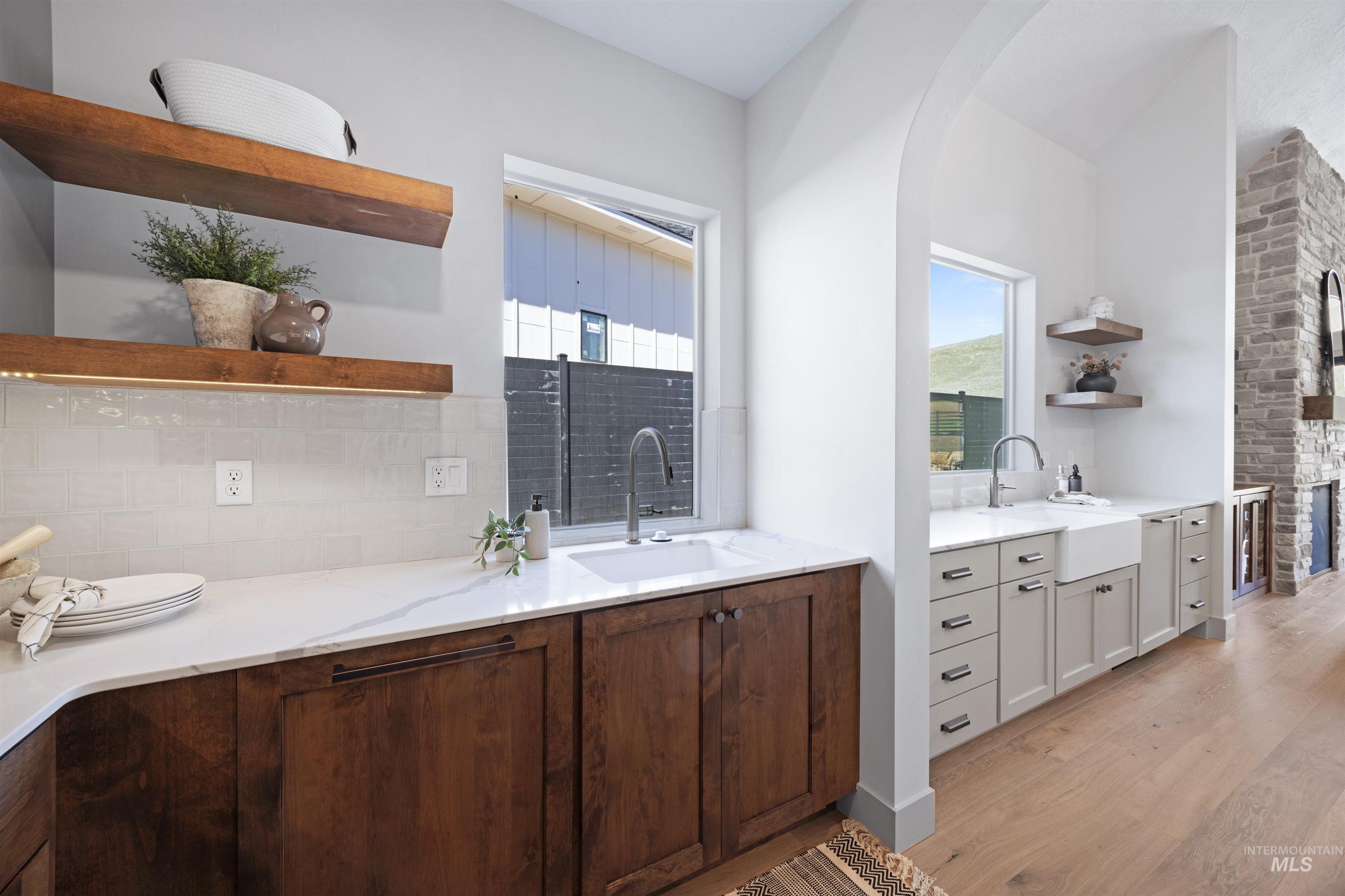 Full bathroom with vanity, light wood-style floors, backsplash, and a fireplace