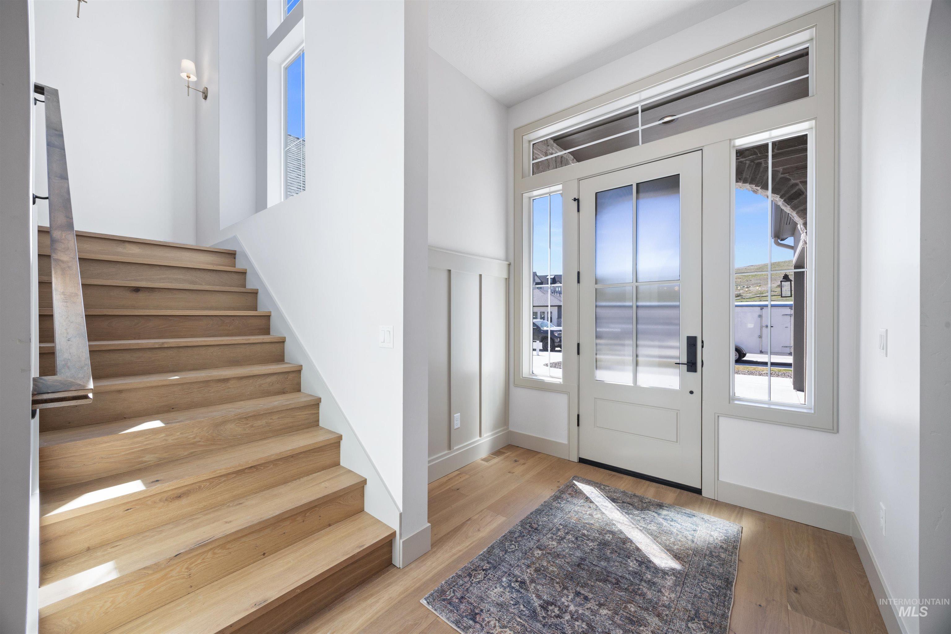 Foyer featuring stairs and light wood-type flooring