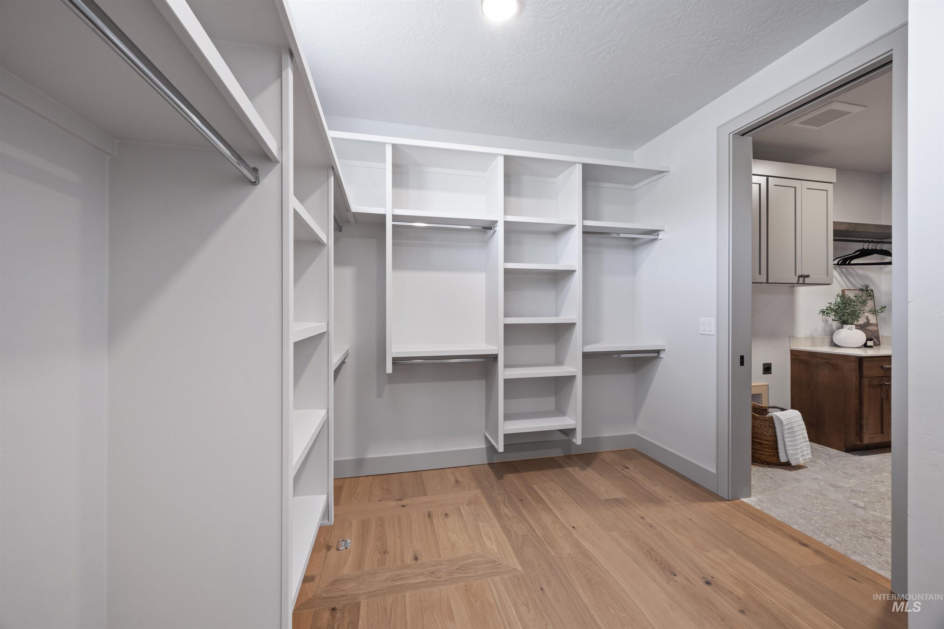 Walk in closet featuring light wood-style floors