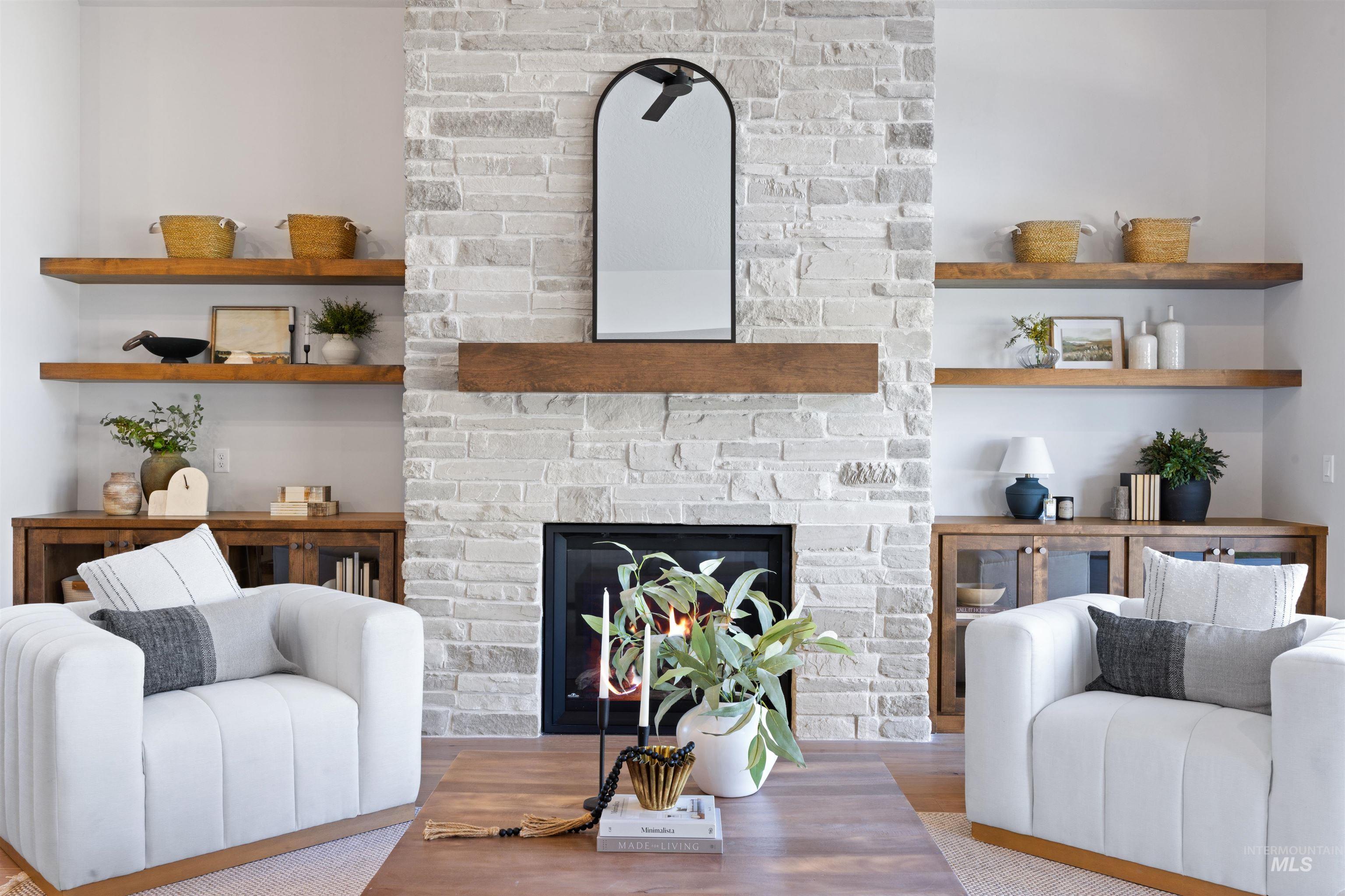 Living area featuring wood finished floors and a large fireplace