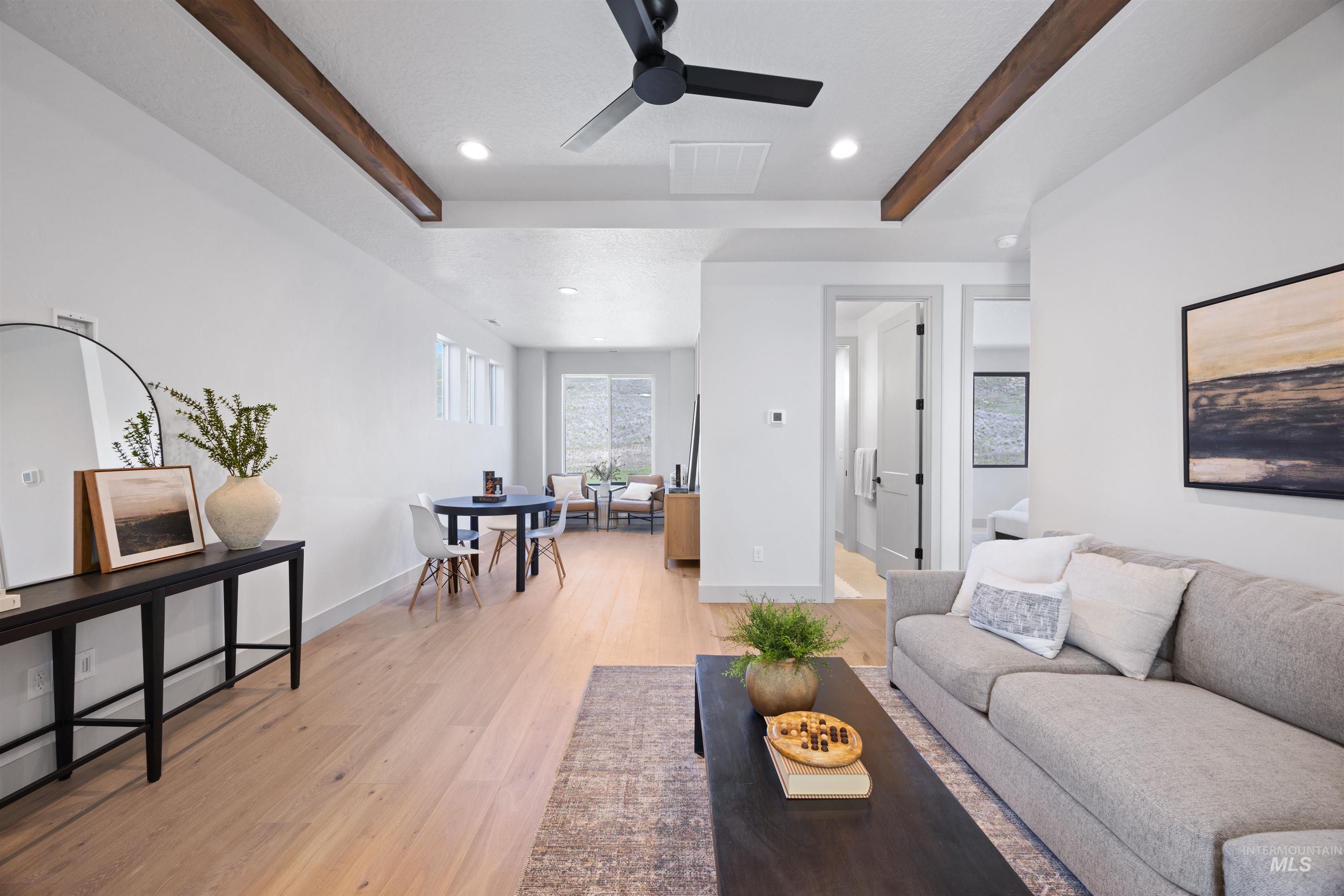 Living room featuring beamed ceiling, light wood-type flooring, recessed lighting, and ceiling fan