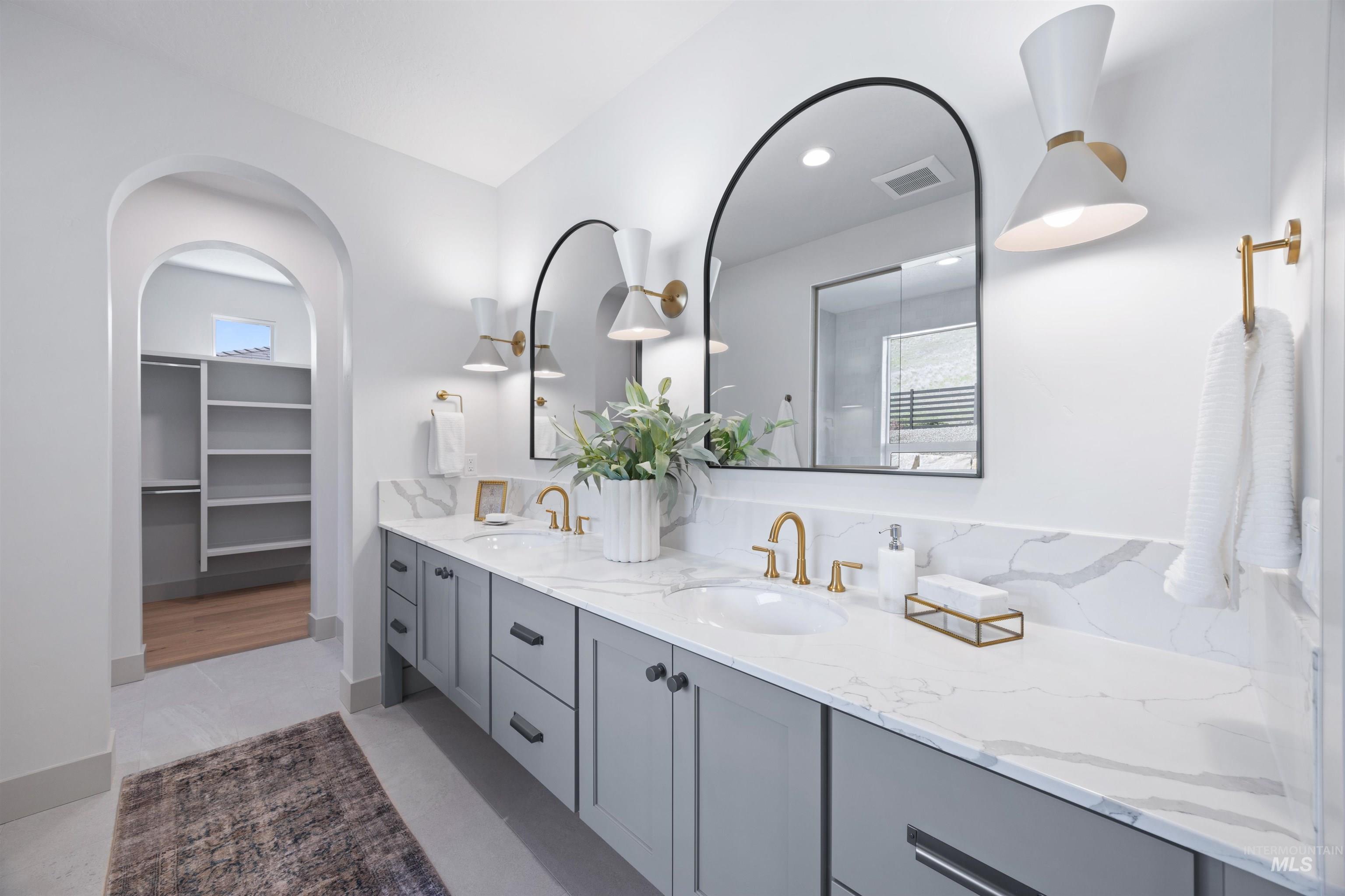 Full bathroom with double vanity and a spacious closet