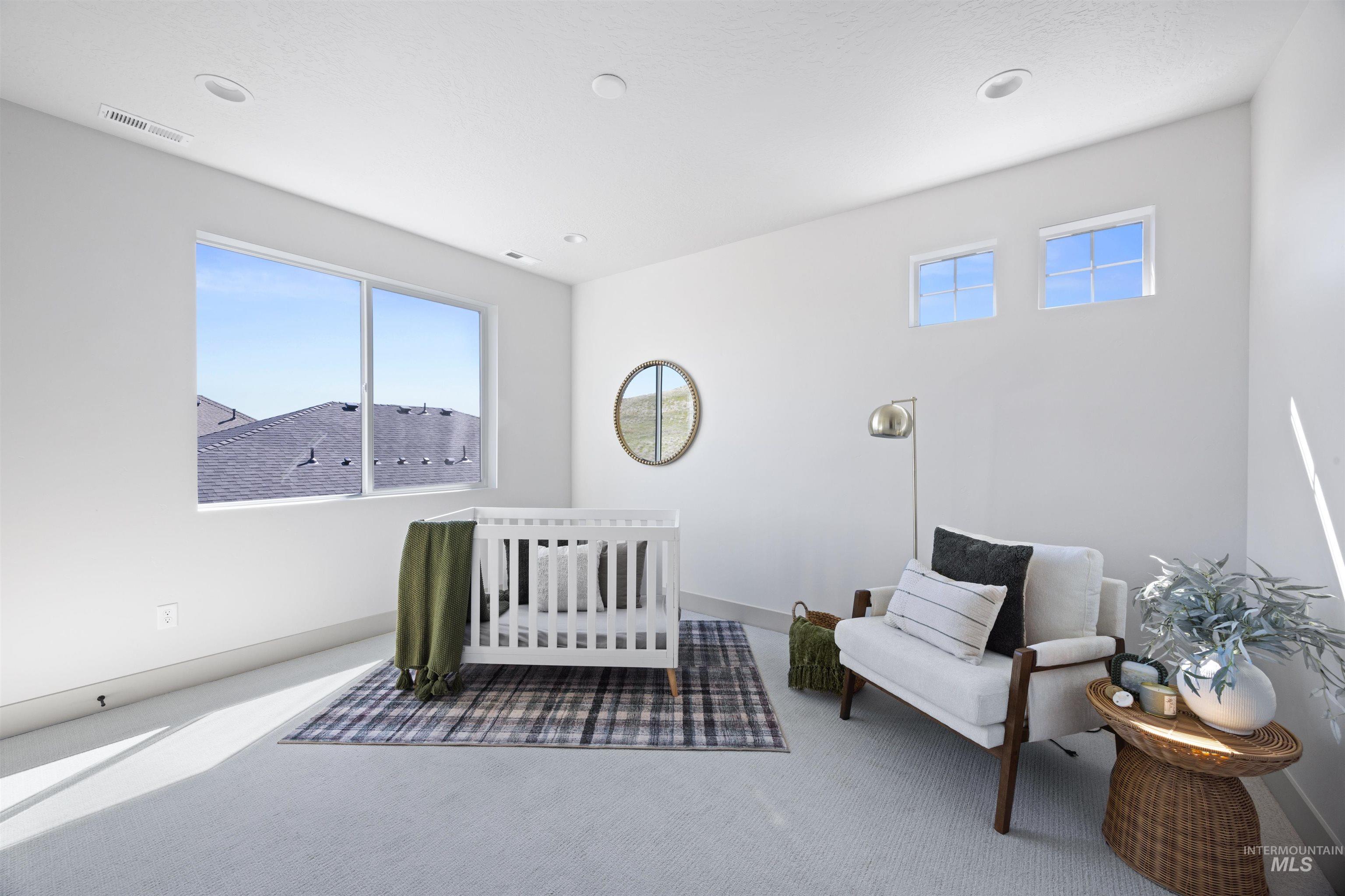 Bedroom featuring a nursery area and carpet flooring