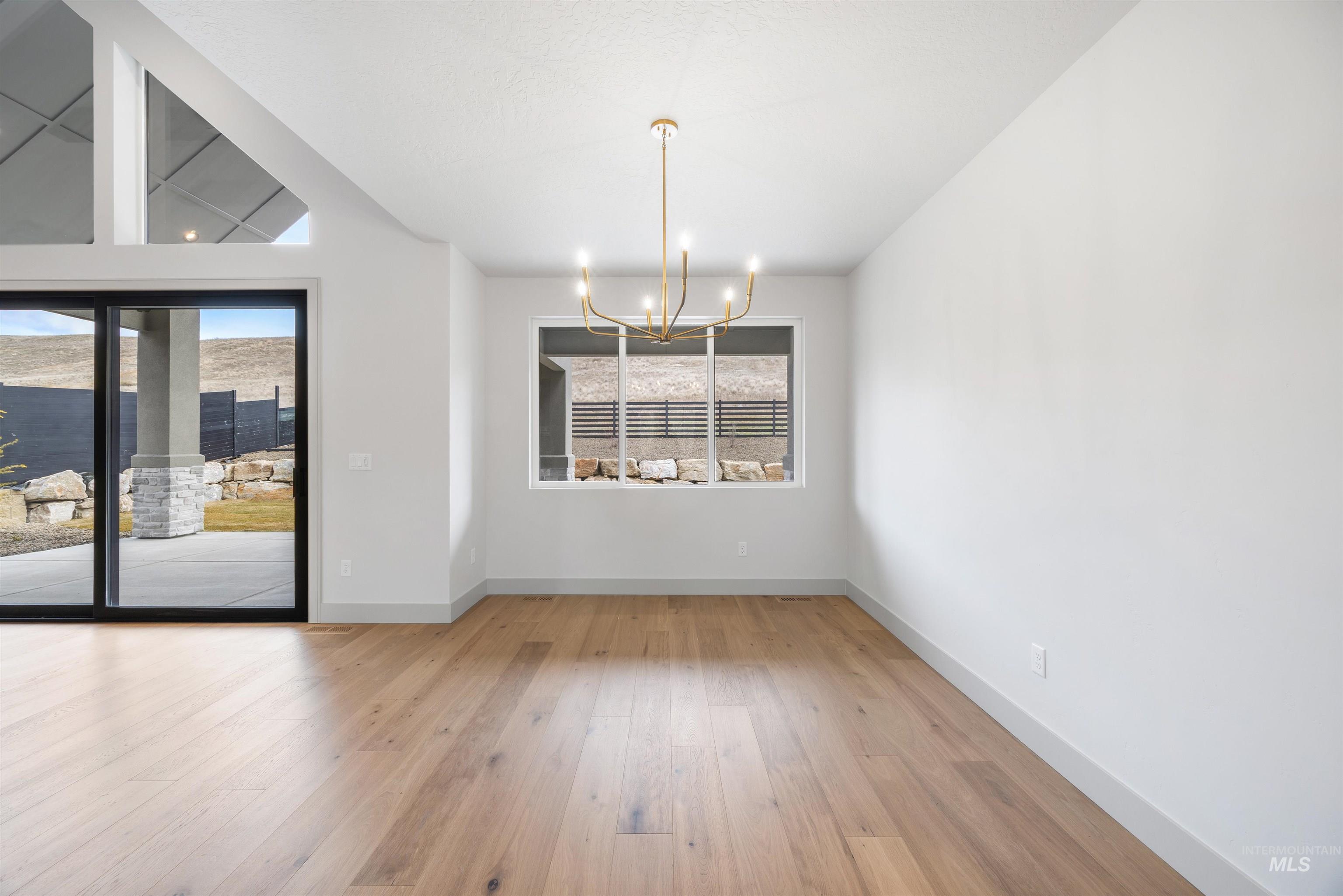 Unfurnished dining area with a chandelier and light wood-type flooring
