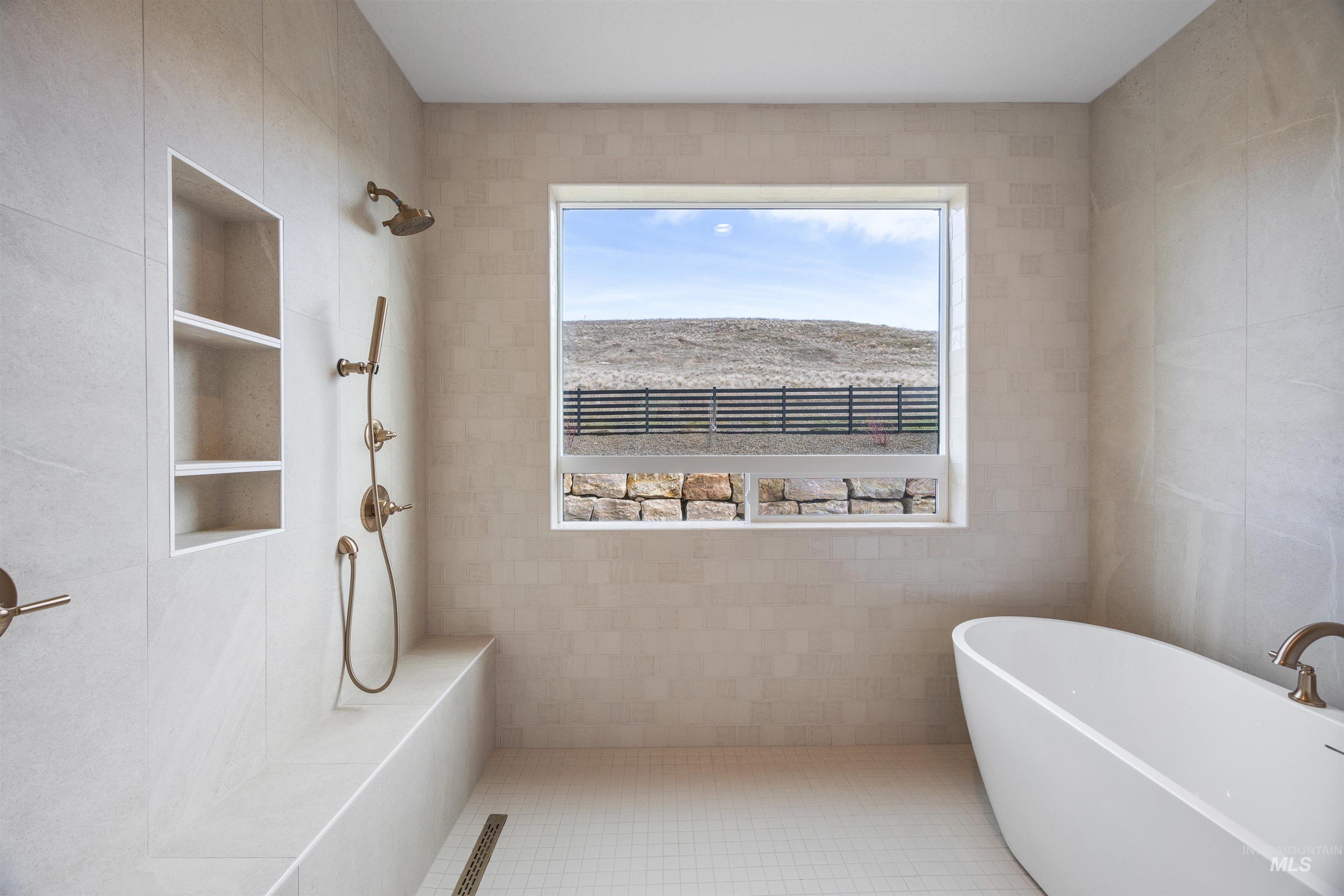Full bath with a freestanding tub, tiled shower, and tile walls