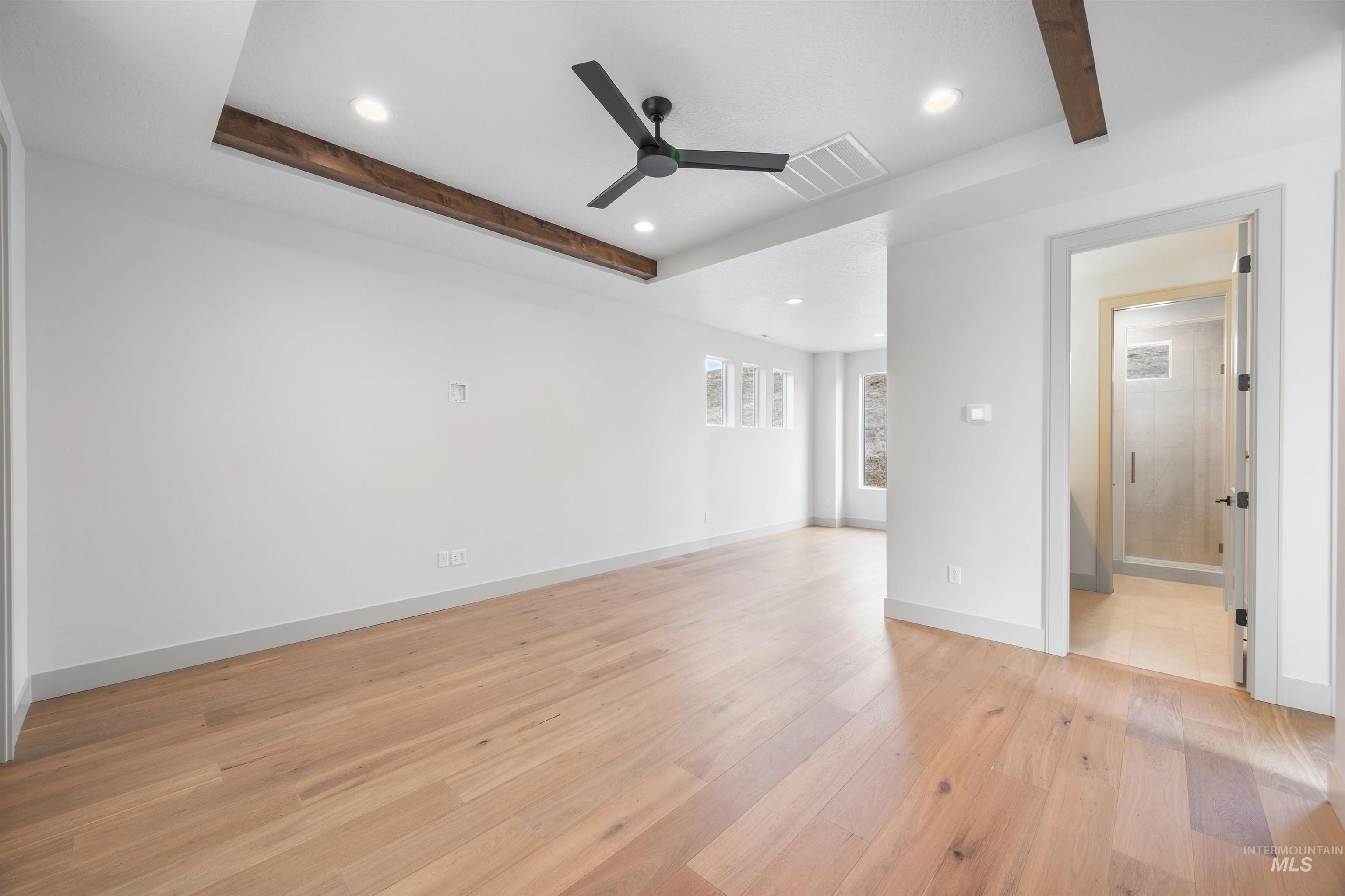 Spare room featuring beam ceiling, recessed lighting, light wood finished floors, and a ceiling fan