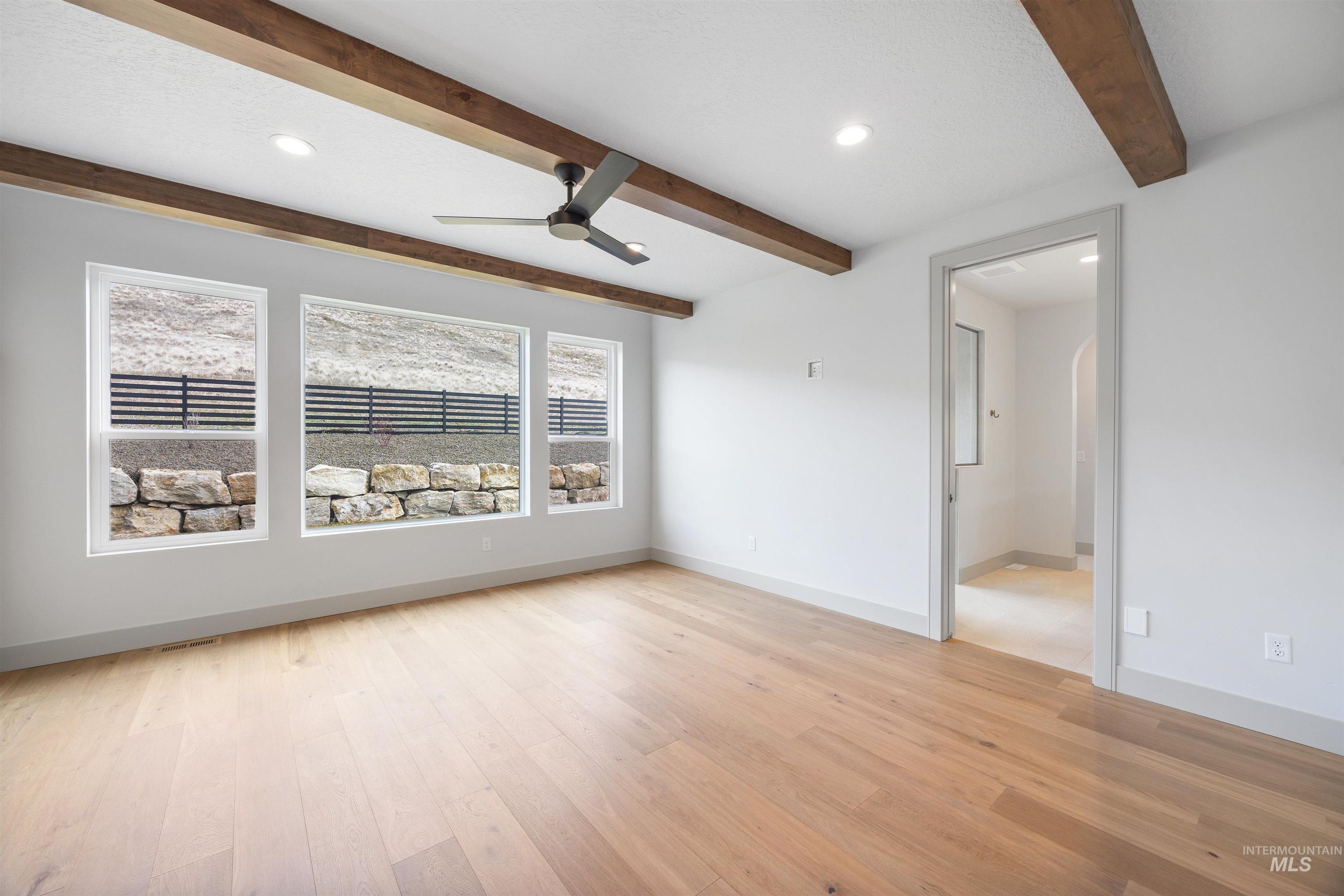 Empty room with ceiling fan, beam ceiling, recessed lighting, and light wood-style flooring