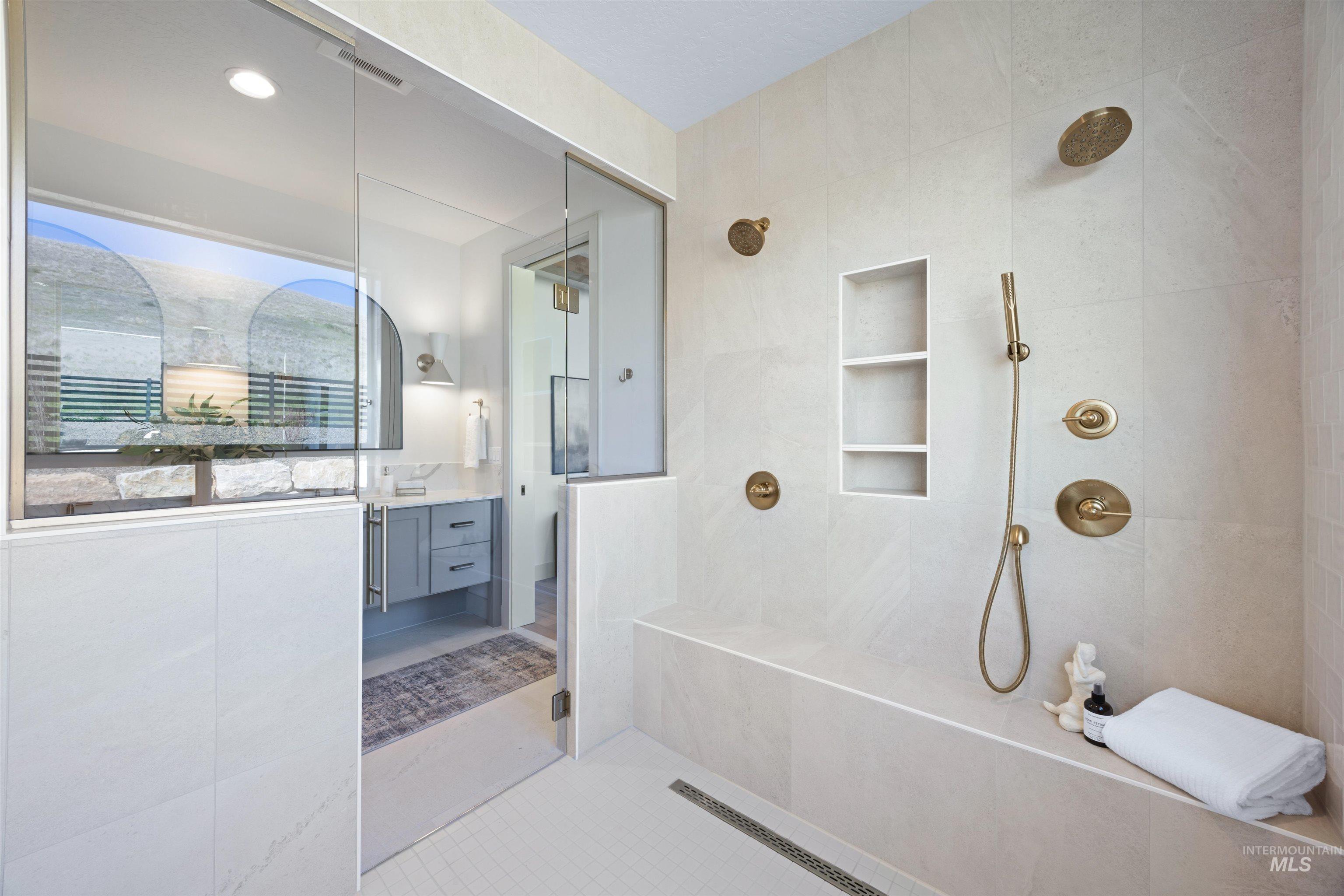 Full bathroom with a tile shower, vanity, light tile patterned floors, and tile walls