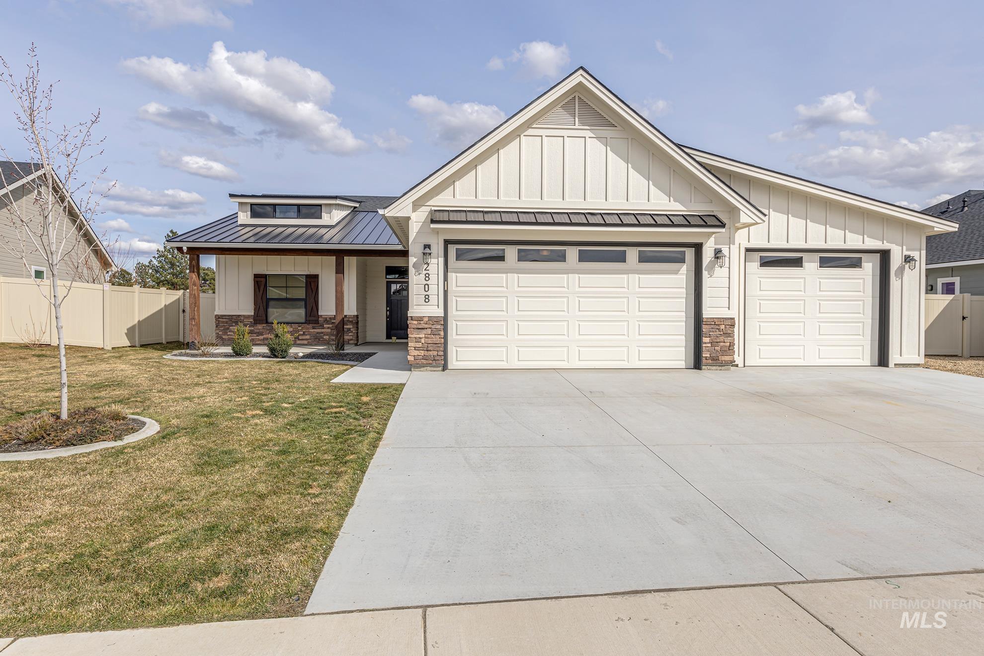 Modern inspired farmhouse with a porch, an attached garage, driveway, and board and batten siding