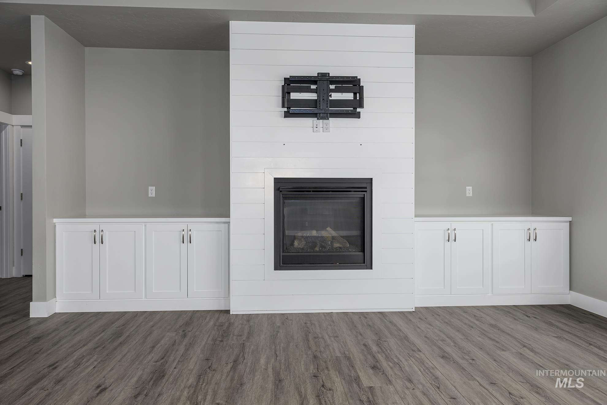Unfurnished living room with a fireplace and dark wood finished floors