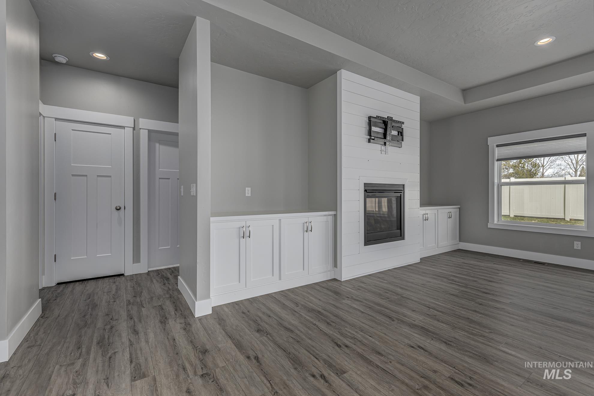 Unfurnished living room featuring recessed lighting, a fireplace, and dark wood finished floors