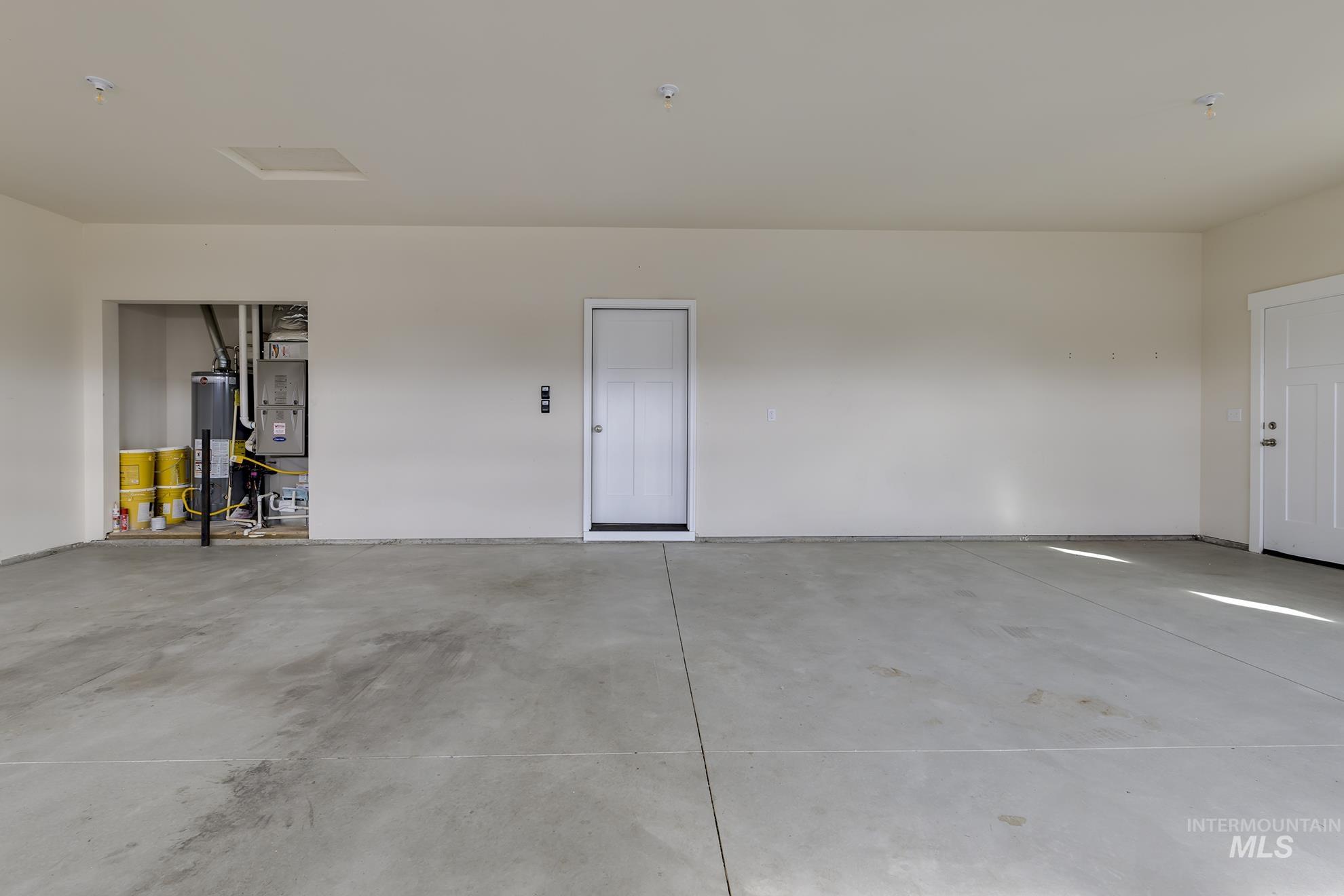 Garage featuring water heater and heating unit