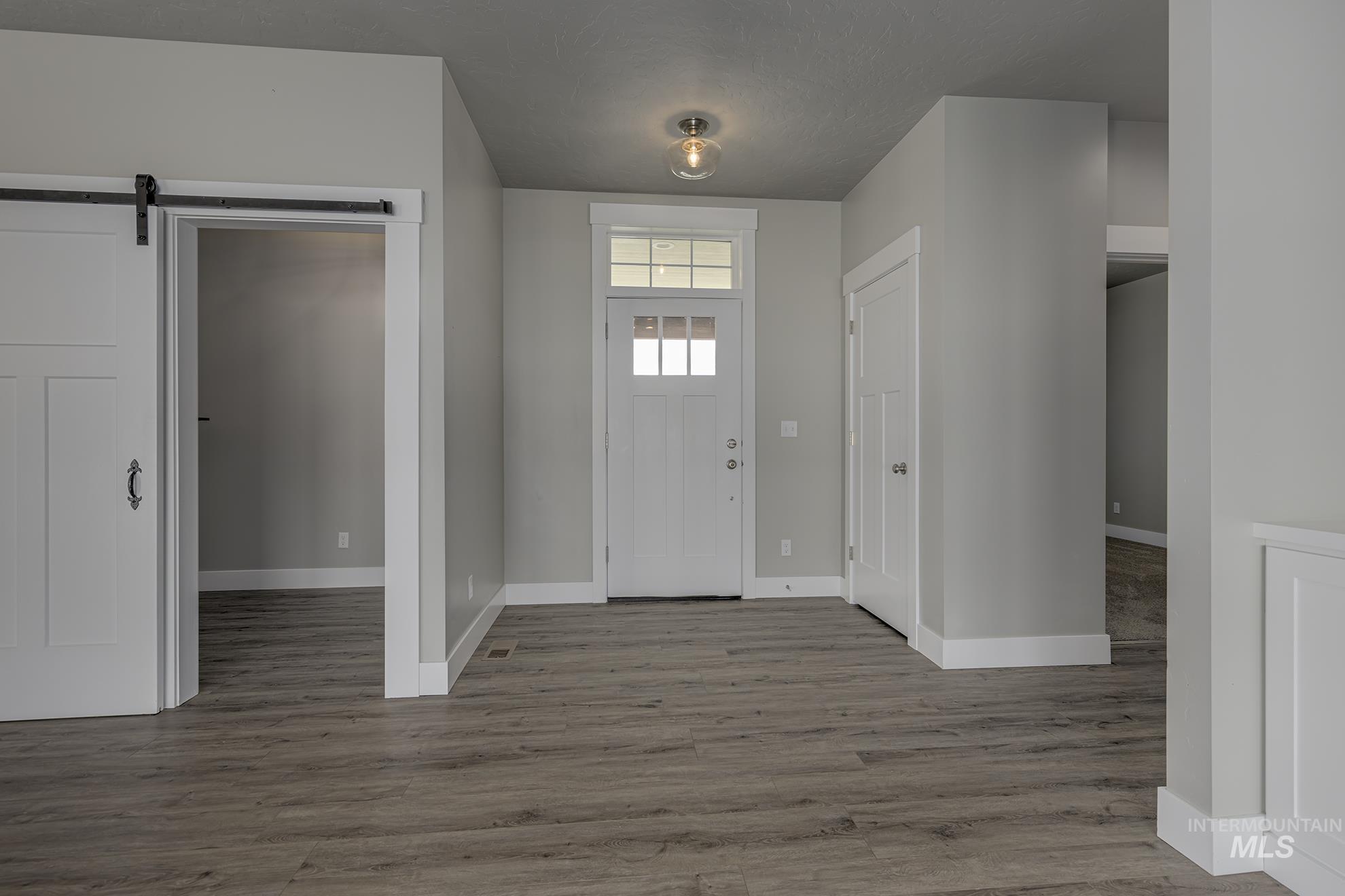 Foyer entrance with a barn door and light wood-type flooring