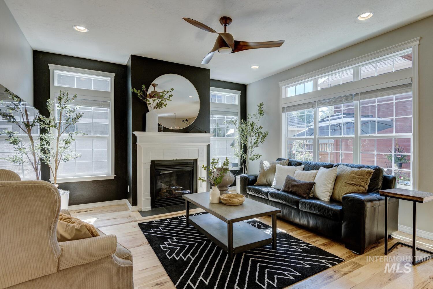 Living area featuring ceiling fan, light wood-style flooring, plenty of natural light, a large fireplace, and recessed lighting
